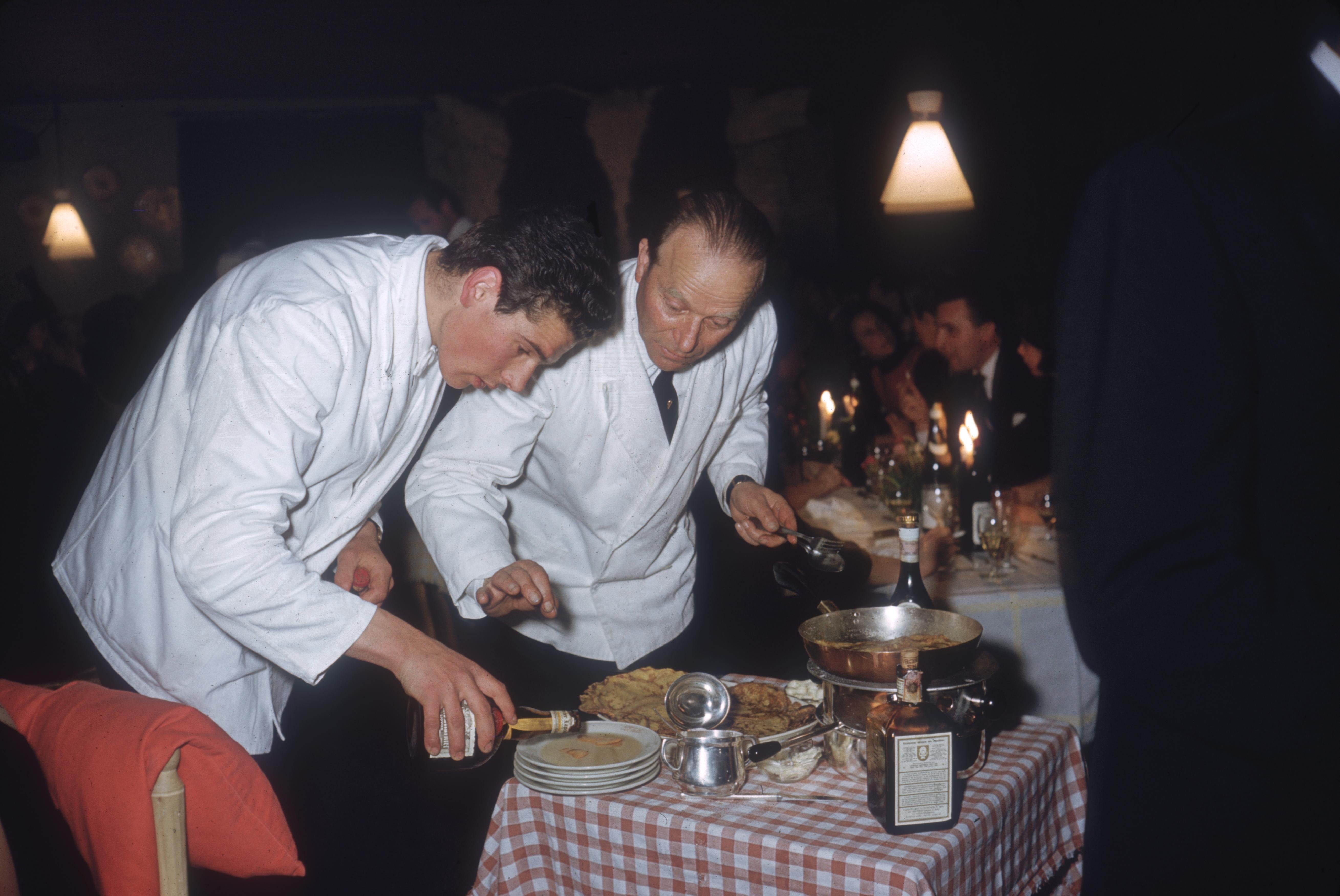 'Cortina d'Ampezzo' 1962 Slim Aarons Limited Estate Edition Print 

Waiters making crepes suzettes at a restaurant in Cortina d'Ampezzo, February 1962. 
(Photo by Slim Aarons/Hulton Archive/Getty Images)

Produced from the original