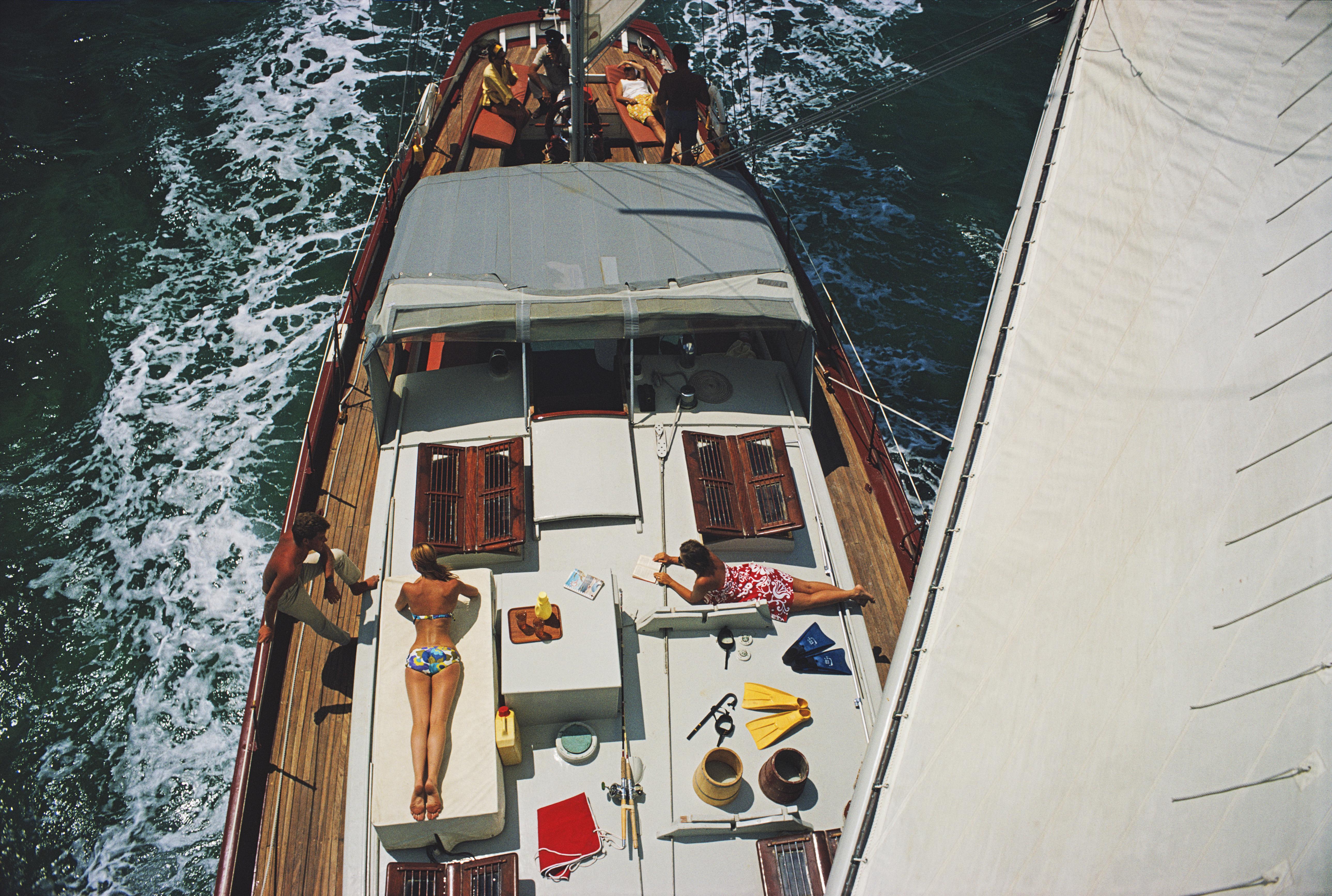 'Deck Dwellers' 1967 Slim Aarons Limited Estate Edition Print 

General view looking down on sunbathers on the deck of the yacht 'Traveler II', off the coast of Exuma in the Bahamas, April 1967. The image has been taken from a vantage point on the
