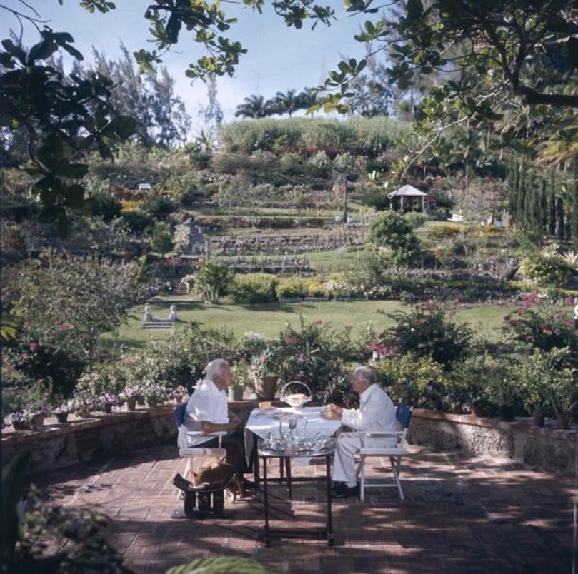 Dining Al Fresco 
1976
by Slim Aarons

Slim Aarons Limited Estate Edition

 Victor Marson (left) and George Amos dine in the garden of Highclere Estate, Barbados, April 1976

unframed
c type print
printed 2023
16×16 inches - paper size


Limited to