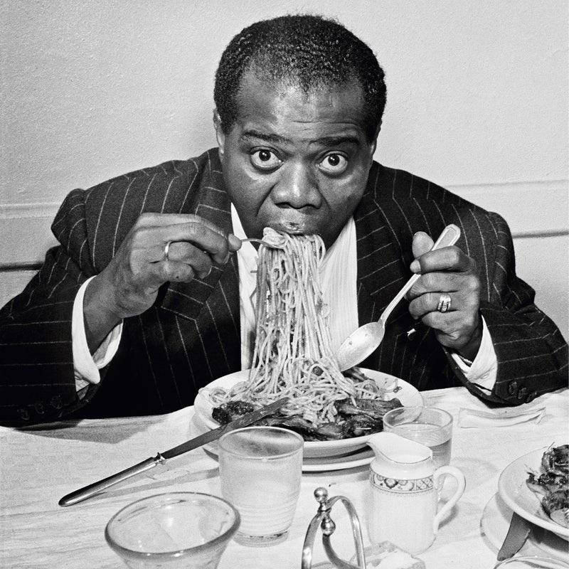 "Dinner Jazz" by Slim Aarons

1949: American Jazz trumpeter and singer Louis Armstrong (1898 - 1971) enjoys a plate of spaghetti in Rome.

Unframed
Paper Size: 40" x 40'' (inches)
Printed 2022 
Silver Gelatin Fibre Print