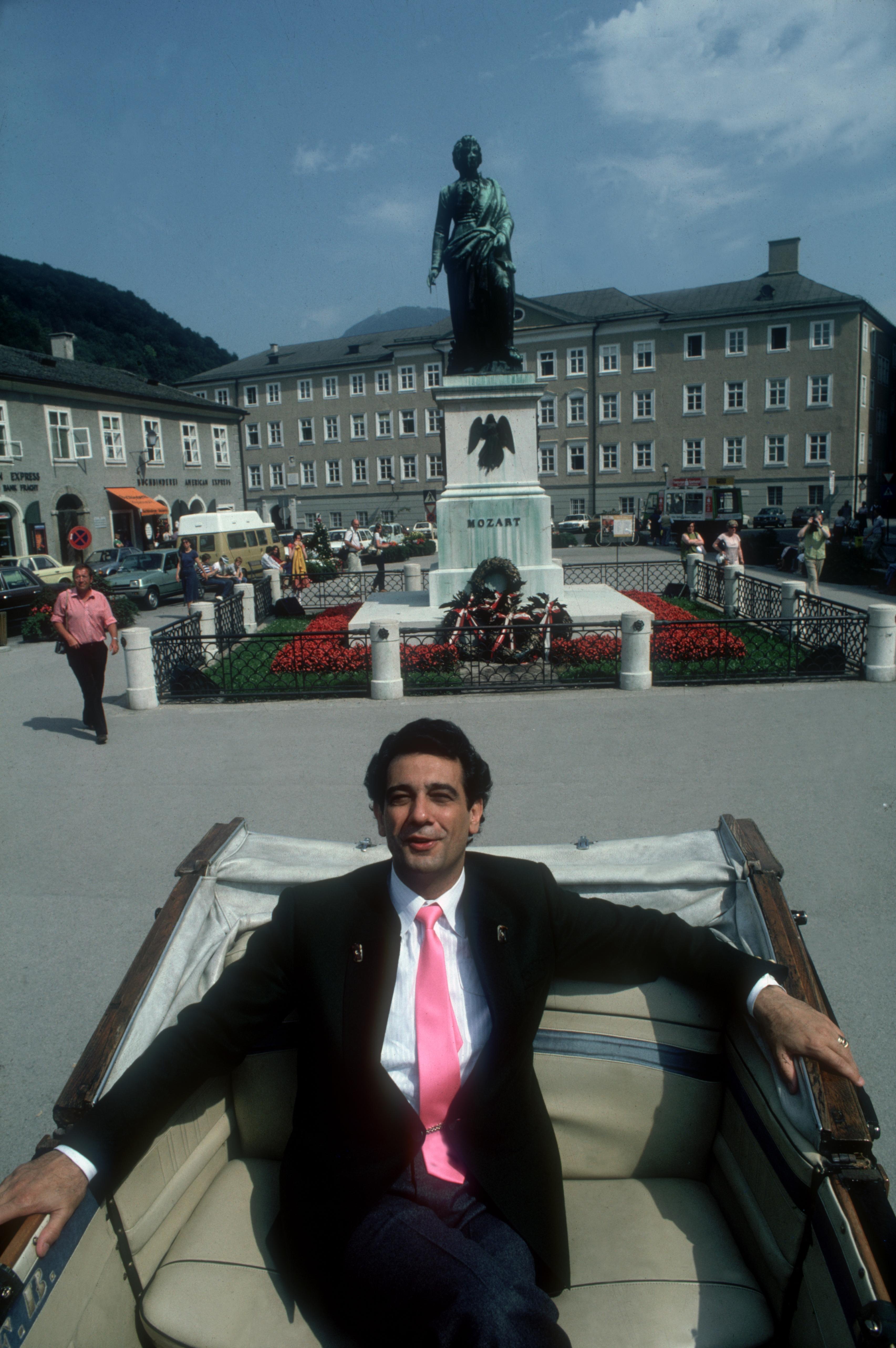 Der spanische Tenor Placido Domingo auf dem Rücksitz eines Autos am Mozartplatz in Salzburg, vor dem Mozart-Denkmal, August 1981.

Slim Aarons Estate Edition, inklusive Echtheitszertifikat
Nummeriert und gestempelt vom Slim Aarons Estate

Moderne