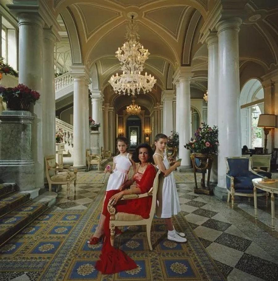 Droulers And Daughters 
1984
by Slim Aarons

Slim Aarons Limited Estate Edition

Roberta Droulers sitting with her daughters, Nathalie and Virginie, in the lobby of the Villa D’Este on Lake Como, Tivoli, near Rome, Italy, circa 1984

unframed
c type