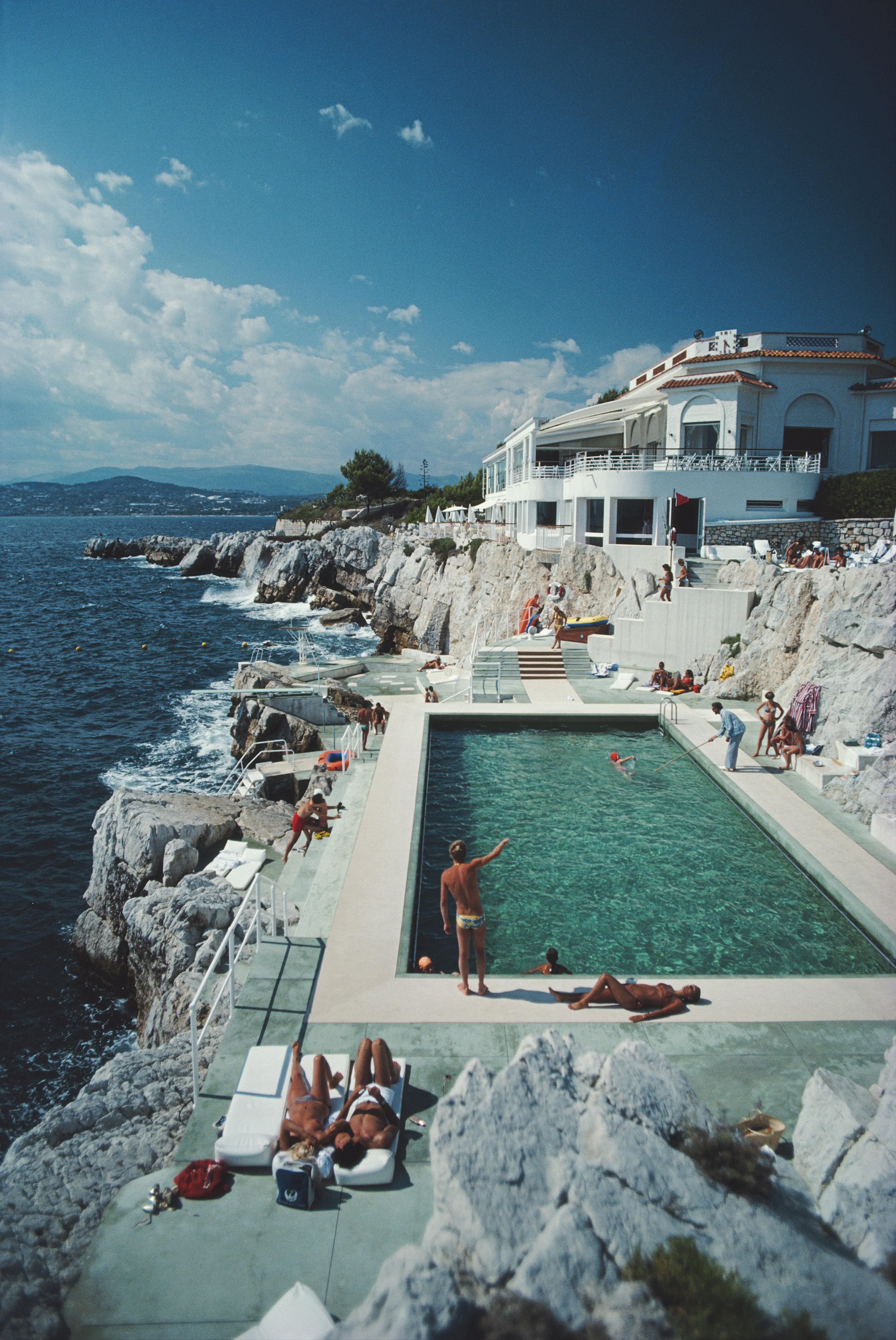 ‘Eden Roc Pool‘ from 1976, is one of the best known French Riviera photographs by American photographer Slim Aarons (1916-2006). It shows the 'Hotel du cap Eden Roc' in Antibes, France, thought to be F. Scott Fitzgerald’s inspiration for the “Hôtel
