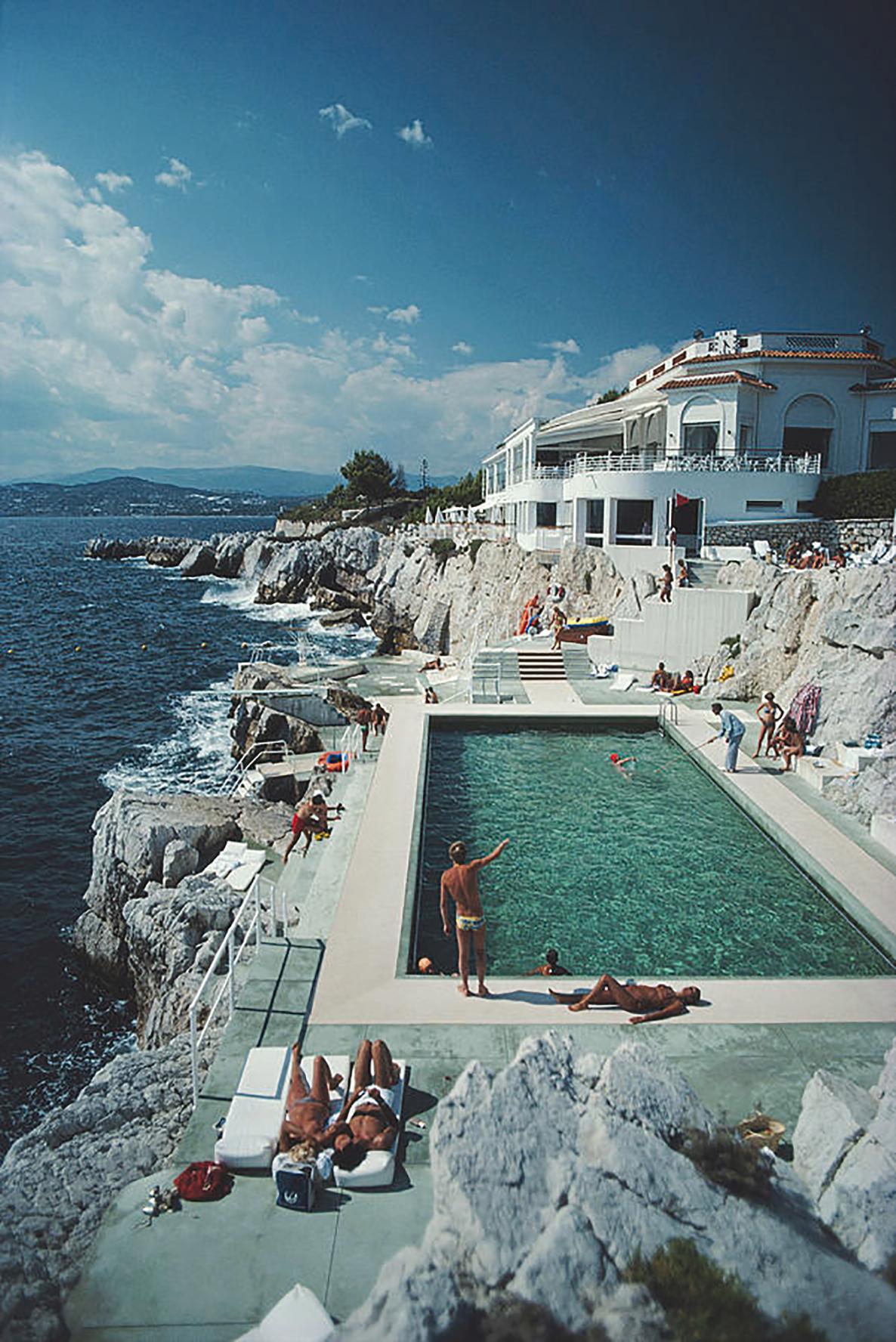 Slim Aarons, Eden-Roc Pool
Estate stamped and hand numbered edition of 150 with certificate of authenticity from the estate. 
Various sizes available

Guests round the swimming pool at the Hotel du Cap Eden-Roc, Antibes, France, August 1976, printed