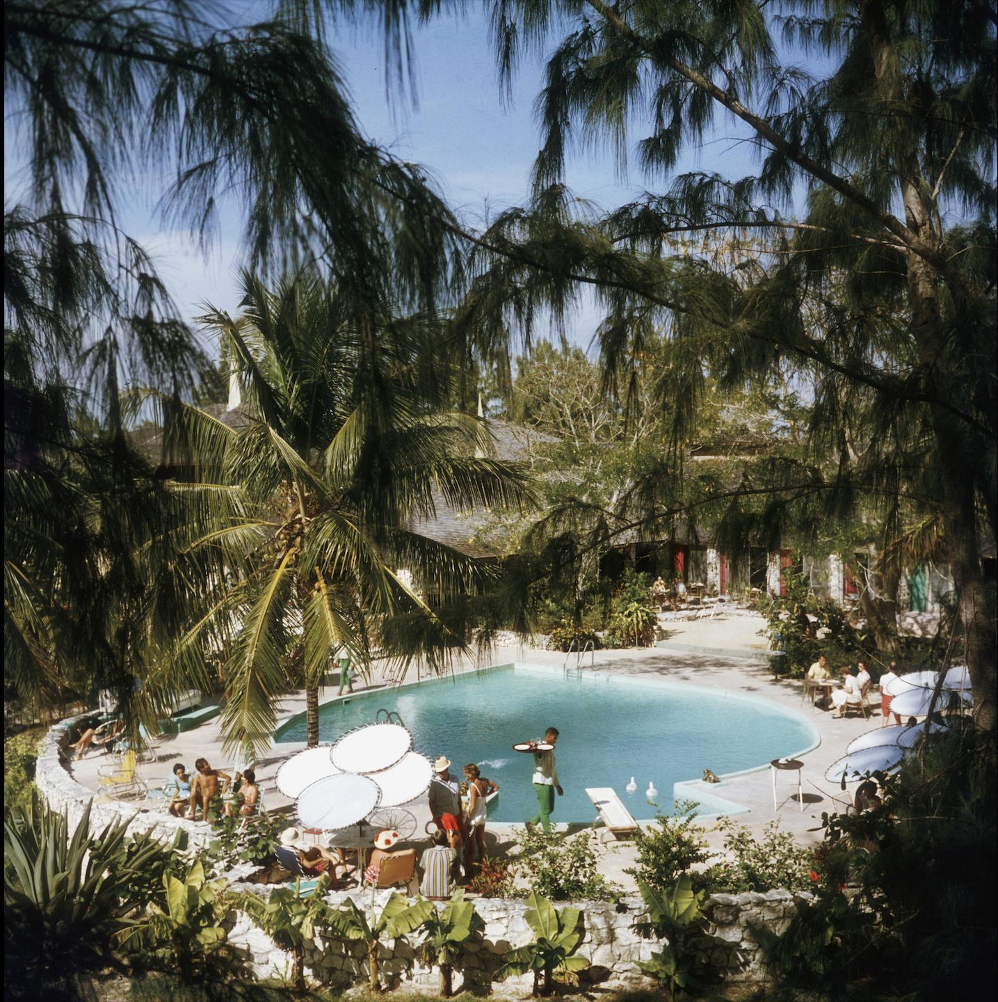 eleuthera Pool Party" von Slim Aarons

LIMITIERTE AUFLAGE MIT NACHLASSSTEMPEL
Mit Tinte nur bis 150 nummeriert und mit Prägestempel auf der Vorderseite.

Gäste im French Leave Hotel, das dem Schauspieler Craig Kelly gehört, auf Eleuthera auf den