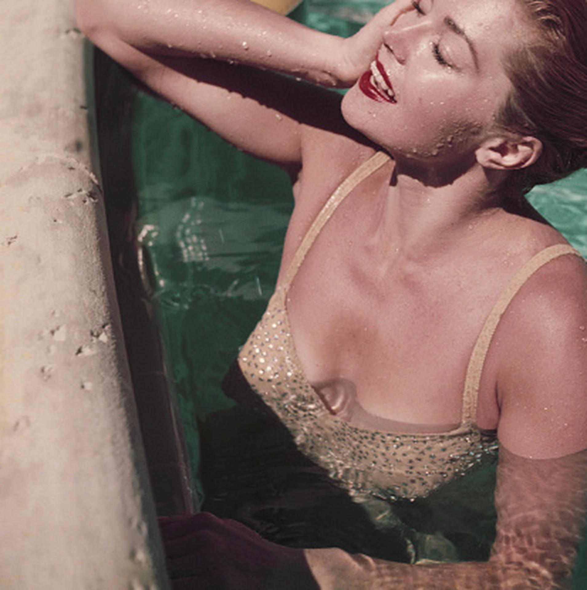 Diese figurative Fotografie des Society-Fotografen Slim Aarons aus den frühen 1950er Jahren zeigt Esther Williams, eine amerikanische Wasserschauspielerin und ehemalige Schwimmmeisterin, beim Entspannen in einem Swimmingpool in Florida.

Dies ist