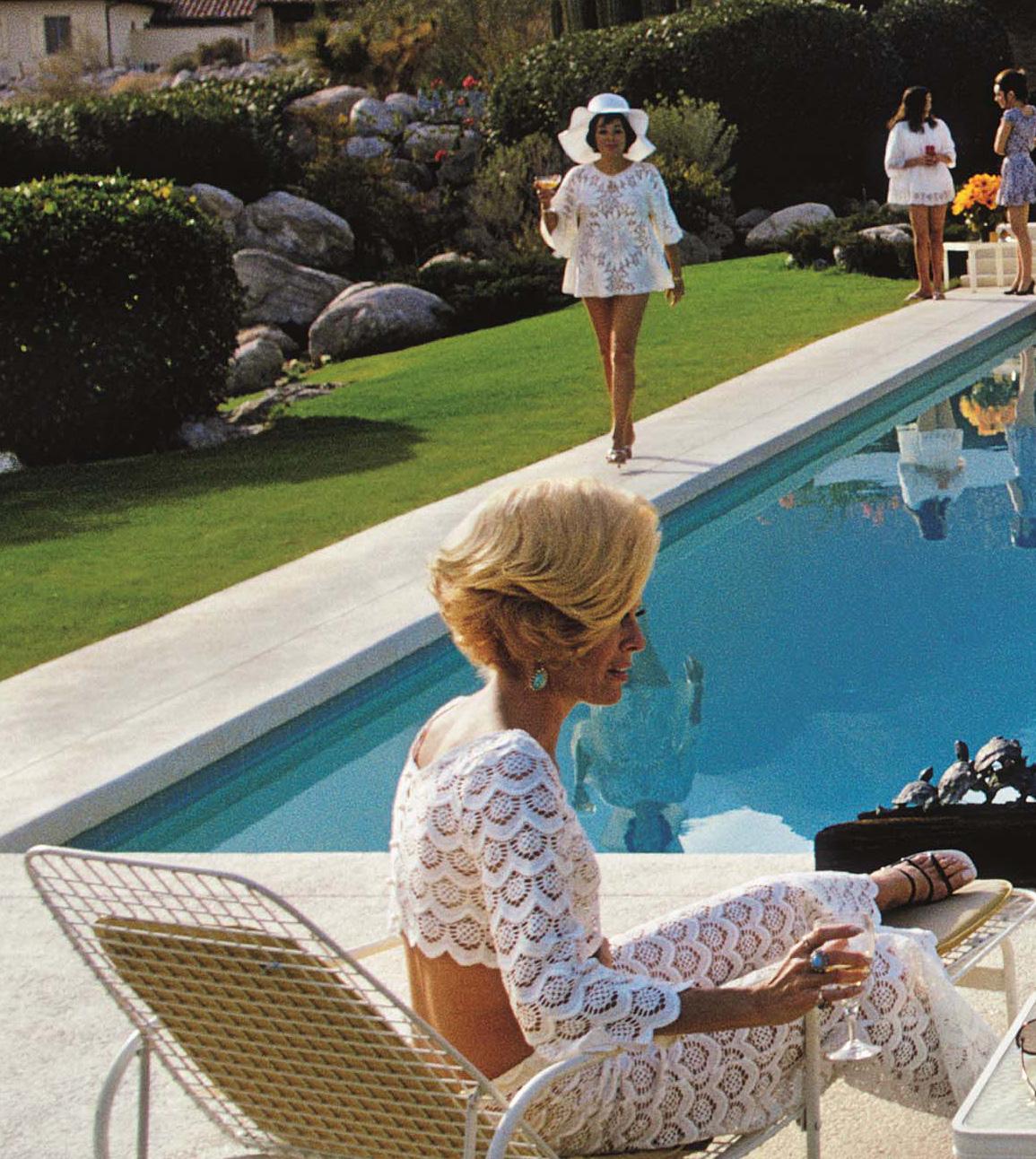 1970: Ein Wüstenhaus in Palm Springs, entworfen von Richard Neutra für Edgar Kaufman. Lita Baron nähert sich Nelda Linsk, rechts, der Frau des Kunsthändlers Joseph Linsk, die sich mit einer Freundin, Helen Dzo Dzo, unterhält.

Dieses Bild ist in