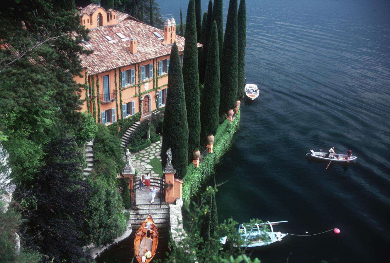 'Giacomo Montegazza' Italy (Slim Aarons Estate Stamped Edition)

Limited Edition Estate Stamped Print (edition size 1/150). 
Giacomo and Stefania Montegazza welcome guests arriving by boat at their villa, La Casinella, on Lake Como, 1983.

This