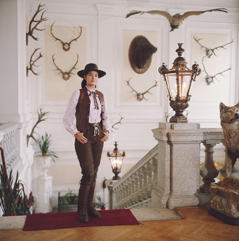 'Gloria Andion' 1983 Slim Aarons Limited Estate Edition Print 

Gloria Andion poses in front of shooting and hunting trophies at the Zidlochovice castle in Moravia, Czech Republic, 1983.

Produced from the original transparency
Certificate of