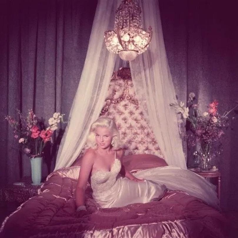 Hello There 
1955
by Slim Aarons

Slim Aarons Limited Estate Edition

 Film star Diana Dors (Diana Fluck) (1931 – 1984) in blonde bombshell pose on a satin covered bed.

unframed
c type print
printed 2023
16×16 inches - paper size


Limited to 150