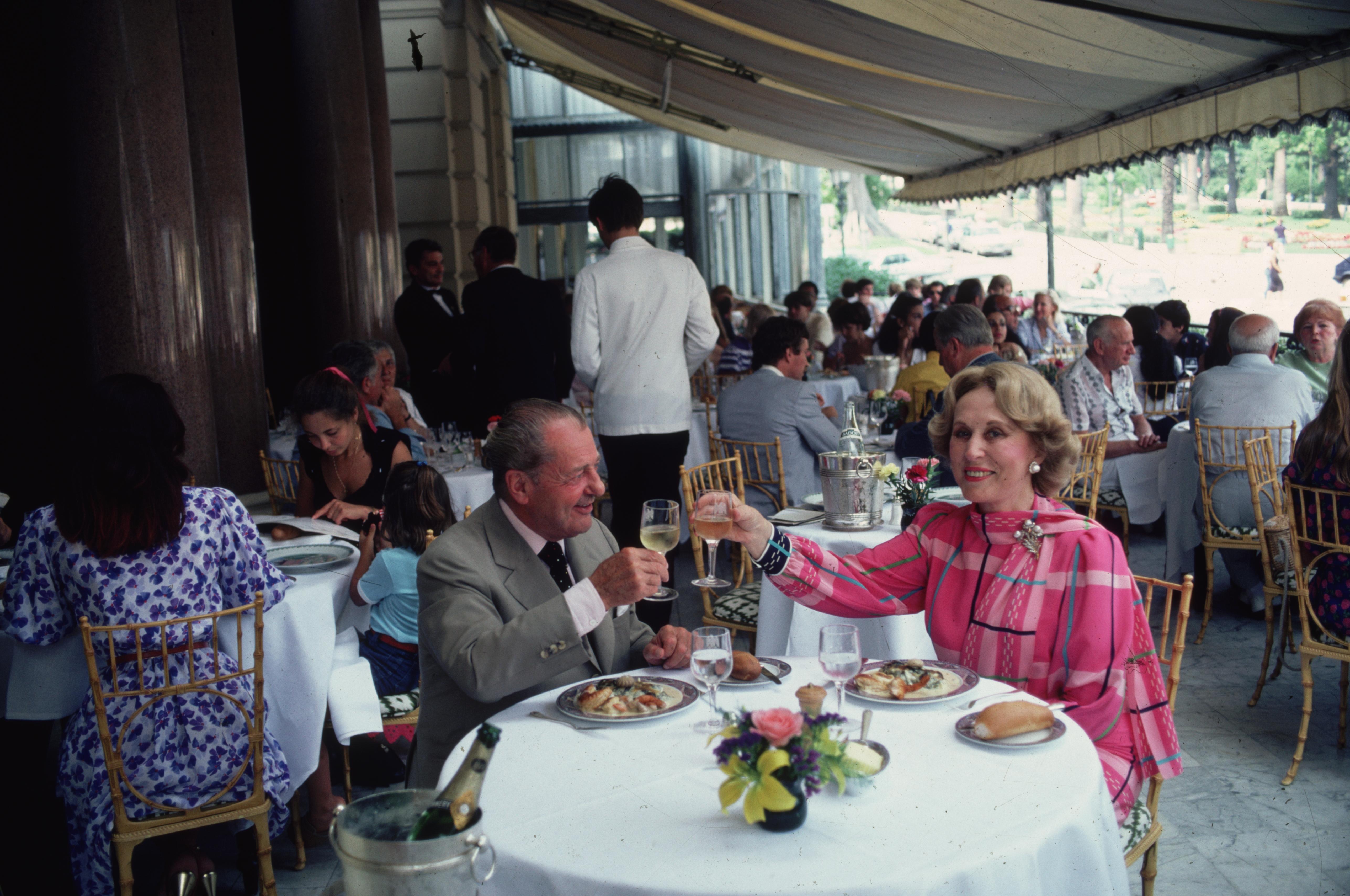'Hotel De Paris' 1981 Slim Aarons Limited Estate Edition Print 

August 1981: Prince de Polignac of Monaco and Estee Lauder sharing a toast before dinner at the Hotel de Paris in Monte Carlo.

Produced from the original transparency
Certificate of