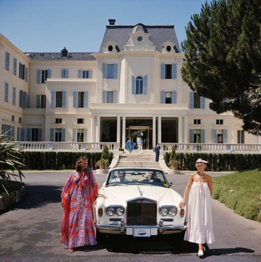 Hotel Du Cap-Eden-Roc 
1976
by Slim Aarons

Slim Aarons Limited Estate Edition

Guests standing by a white Rolls-Royce convertible courtesy car at the Hotel du Cap-Eden-Roc, Antibes, France, August 1976

unframed
c type print
printed 2023
16×16