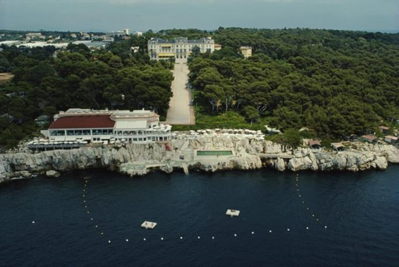 Hotel Du Cap-Eden-Roc 
1976
von Slim Aarons

Slim Aarons Limited Estate Edition

Luftaufnahme des Hotels du Cap-Eden-Roc in Antibes an der Côte d'Azur, August 1976. 

ungerahmt
C Typ Druck
gedruckt 2023
16×20 Zoll - Papierformat


Begrenzt auf 150