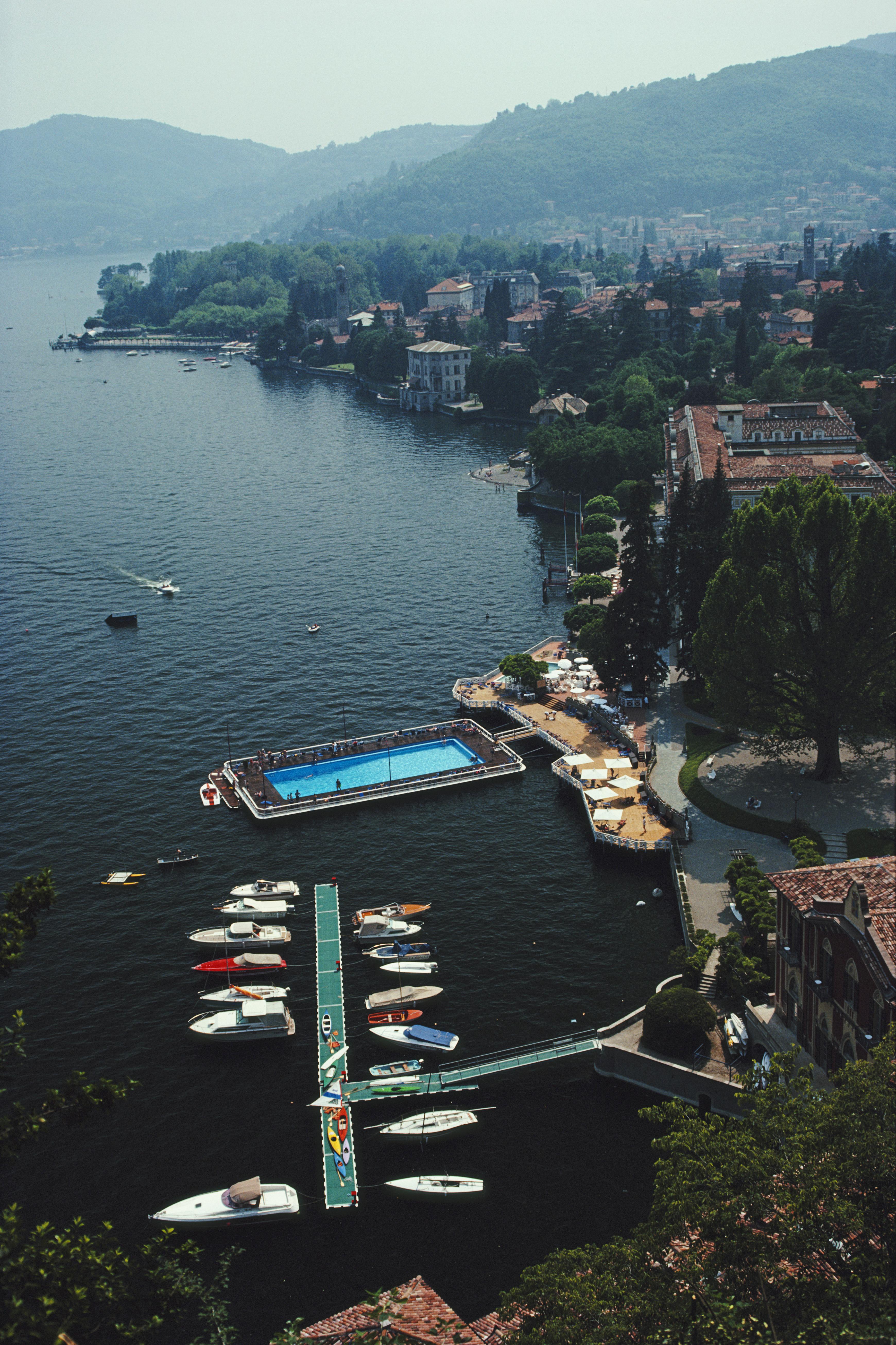 'Hotel On Lake Como' 1983 Slim Aarons Limited Estate Edition Print 

The swimming pool and jetty at the Villa d'Este Hotel, Lake Como, Italy, June 1983. 

Produced from the original transparency
Certificate of authenticity supplied 
Archive