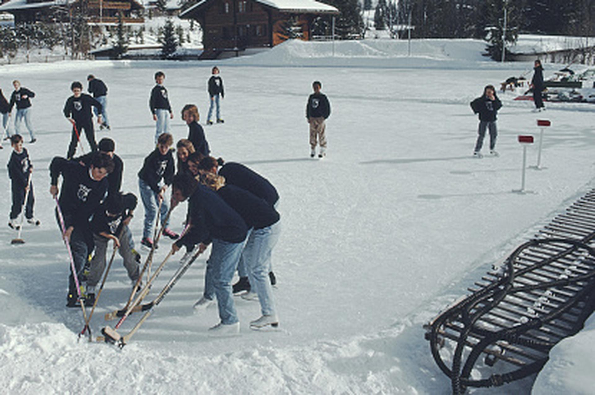 Hockey sobre hielo, Suiza, Edición limitada, Fotografía de paisaje

Esta fotografía invernal de principios de la década de 1990, captada por el fotógrafo de sociedad Slim Aarons, muestra a un grupo de personas jugando un partido improvisado de
