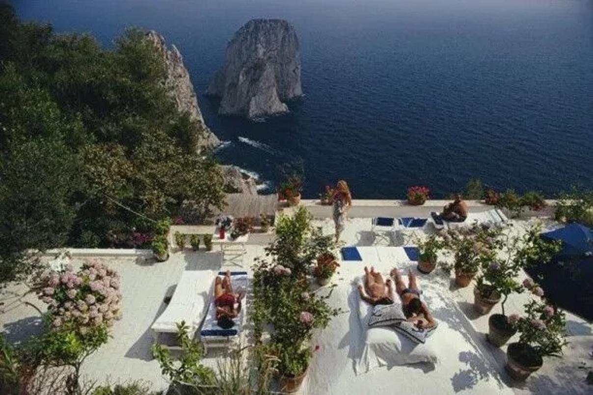 Il Canille 
1980
by Slim Aarons

Slim Aarons Limited Estate Edition

Sunbathers lounge on the white-painted terrace of Il Canille, built into the rocks of Pizzolungo overlooking the waters off the coast of the island of Capri, Italy, in August 1980.