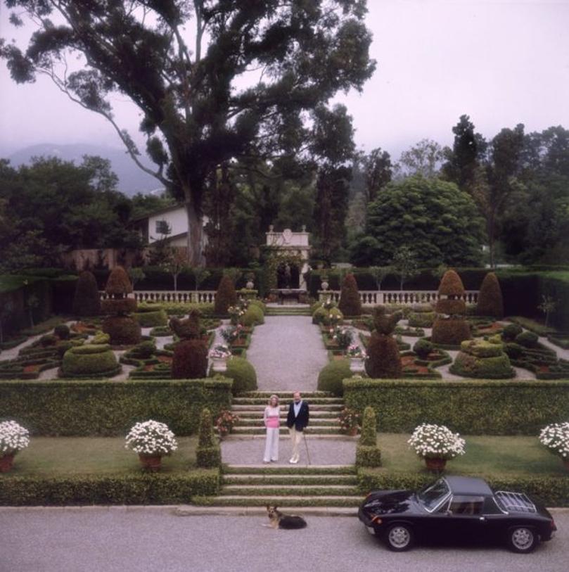 J. Gordon Douglas 
1970
by Slim Aarons

Slim Aarons Limited Estate Edition

Mr. and Mrs. J Gordon Douglas in the formal gardens of their residence, Santa Barbara, California, USA, circa 1970.

unframed
c type print
printed 2023
20 x 20"  - paper