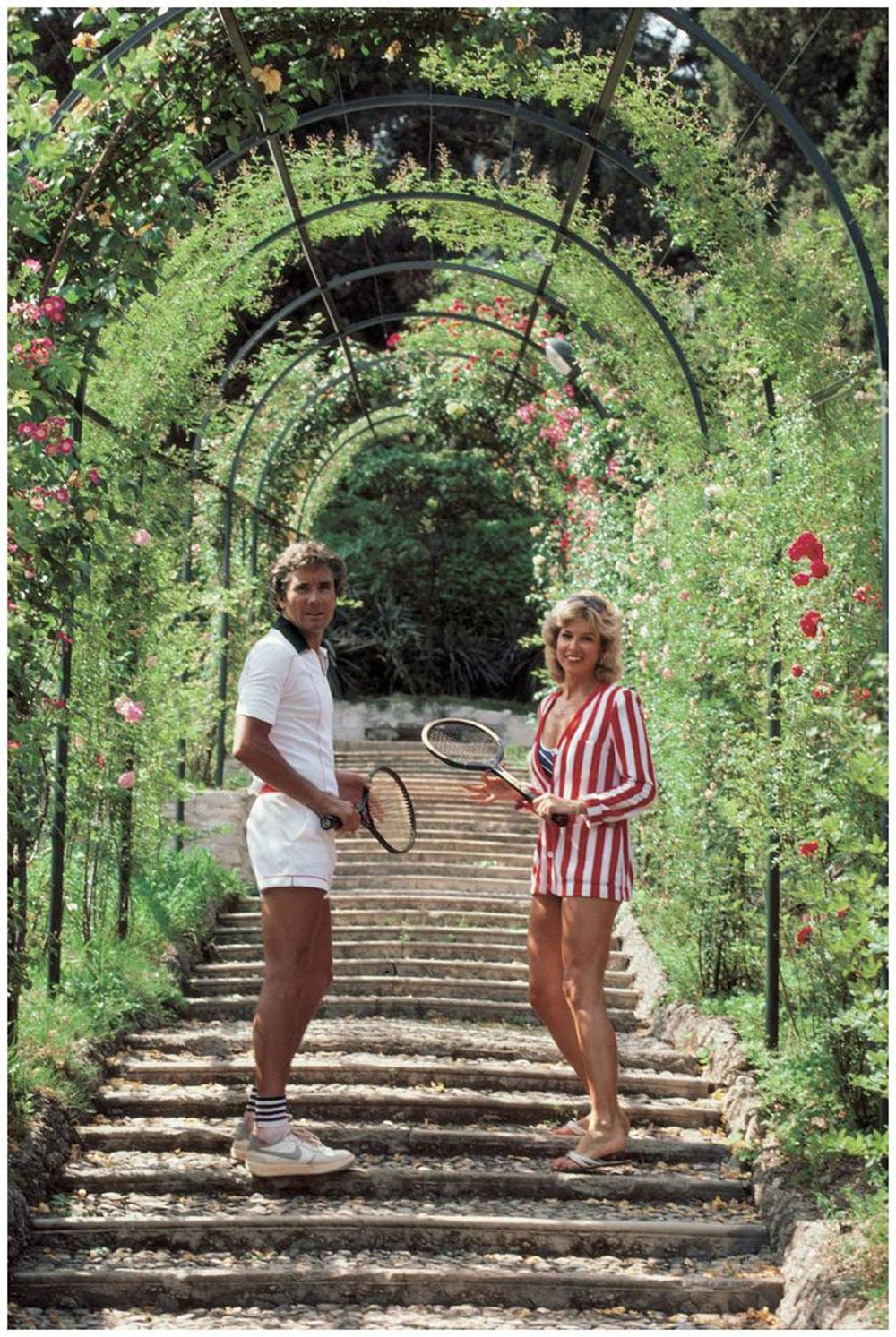 Slim Aarons Landscape Photograph - Jack and GeeGee Entz on Rose-Canopied Steps, Tivoli