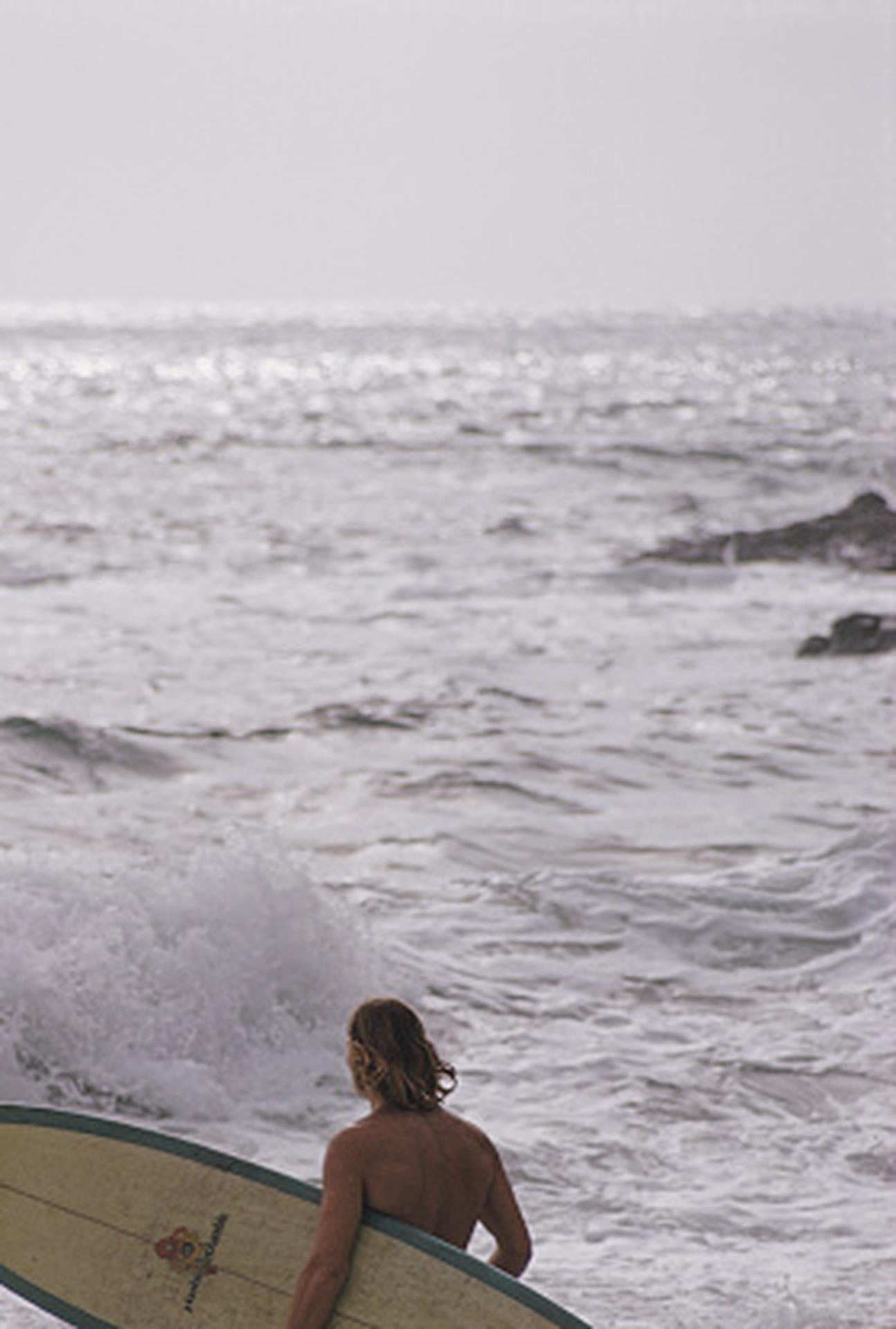Este retrato fotográfico de principios de la década de 1970, capturado por el fotógrafo de sociedad Slim Aarons, muestra a un surfista en el mar en Laguna Beach, California.

Se trata de una edición sellada y numerada a mano de 150 ejemplares, con