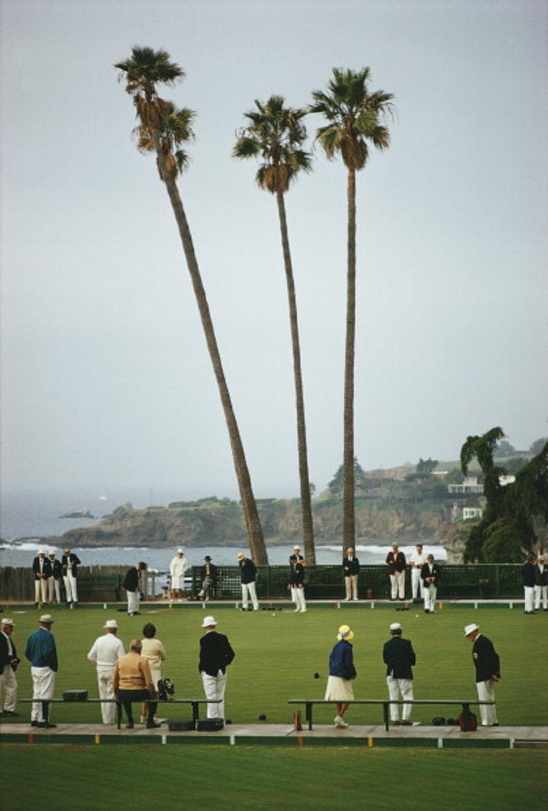 'Laguna Bowls'  1970 Slim Aarons Limited Estate Edition Print 

A game of bowls in progress at Laguna Beach Lawn Bowling Club in Heisler Park, southern California, circa 1970. Members and guests have to observe a strict dress code. (Photo by Slim