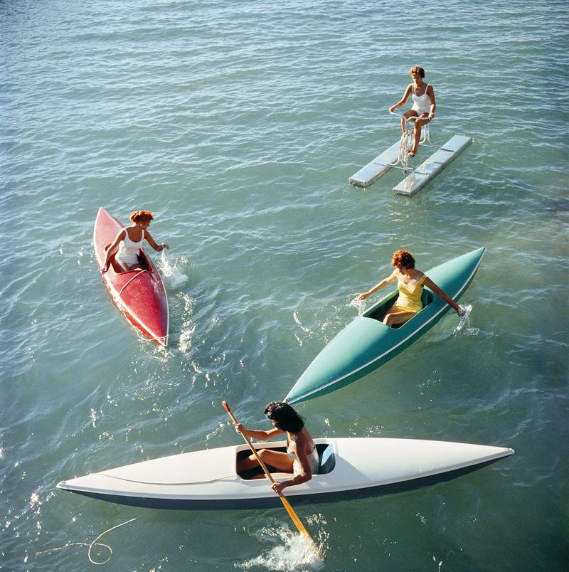 Voyage au lac Tahoe 

Jeunes femmes faisant du canoë sur le côté Nevada du lac Tahoe, 1959.

Une scène fabuleuse représentant quatre jeunes femmes faisant du canoë et du pédalo sur les magnifiques eaux vertes du lac Canoë, leurs maillots de bain et