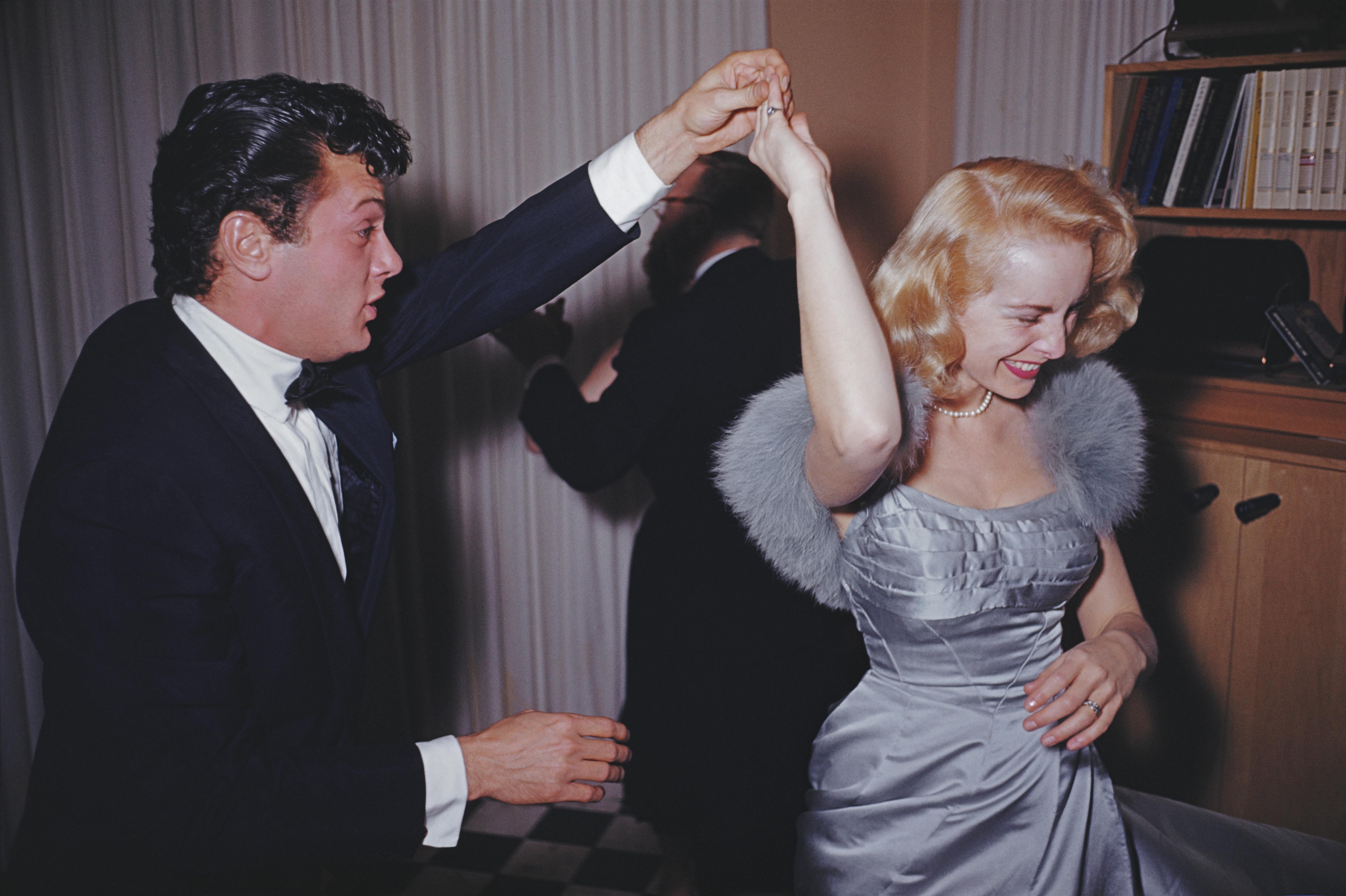 'Let's Twirl'  Slim Aarons Limited Estate Edition Print 

Film stars Tony Curtis (Bernard Schwarz) and his wife Janet Leigh (Jeanette Morrison) enjoying a dance at a Beverly Hills party held at James Mason's home.

Produced from the original