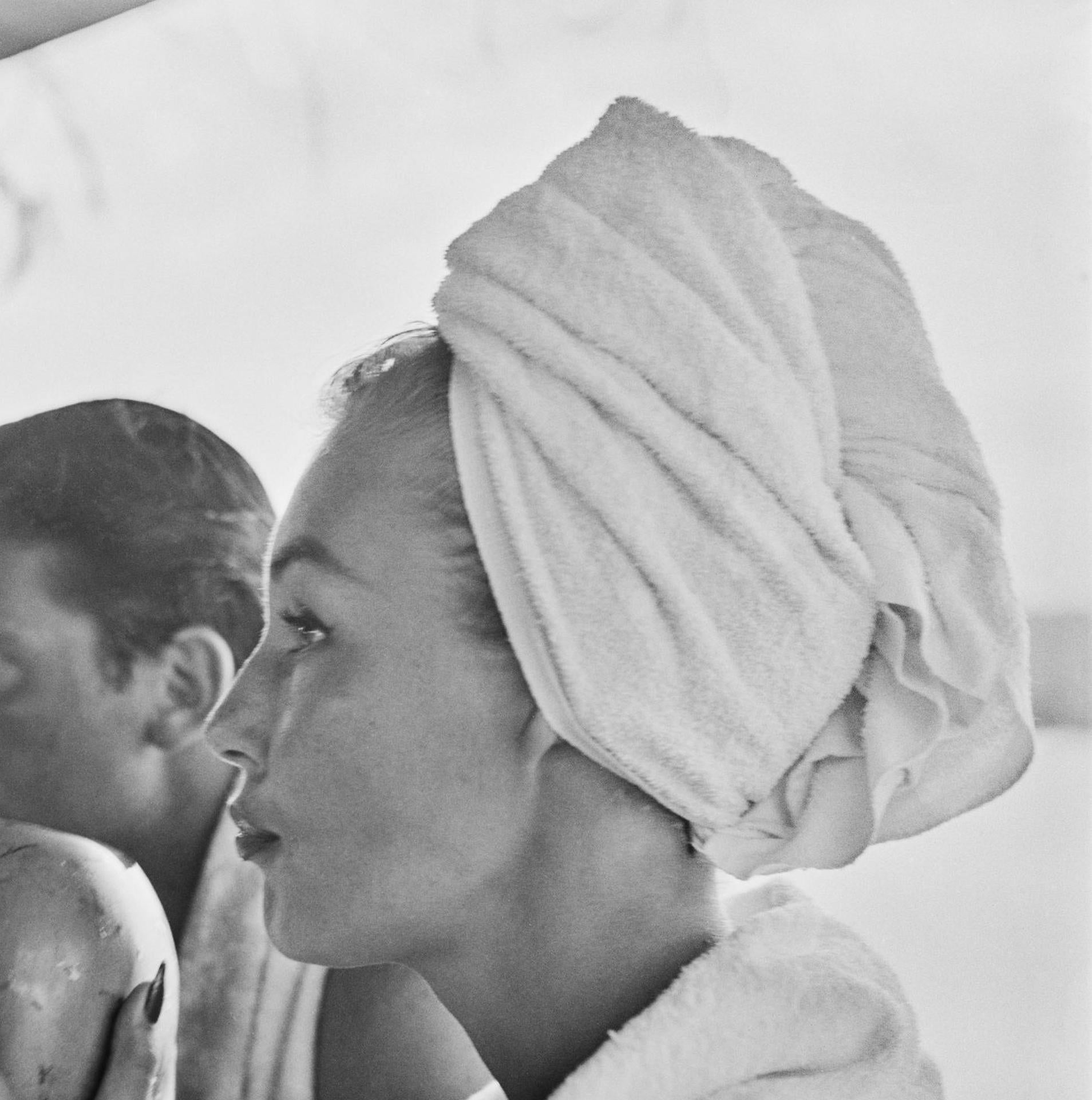 Dieses Porträtfoto des Society-Fotografen Slim Aarons aus den frühen 1950er Jahren zeigt das Fotomodell Liz Pringle beim Trinken aus einer Kokosnuss im Round Hill Resort in Montego Bay, Jamaika.

Dies ist eine nachlassgestempelte und handnummerierte