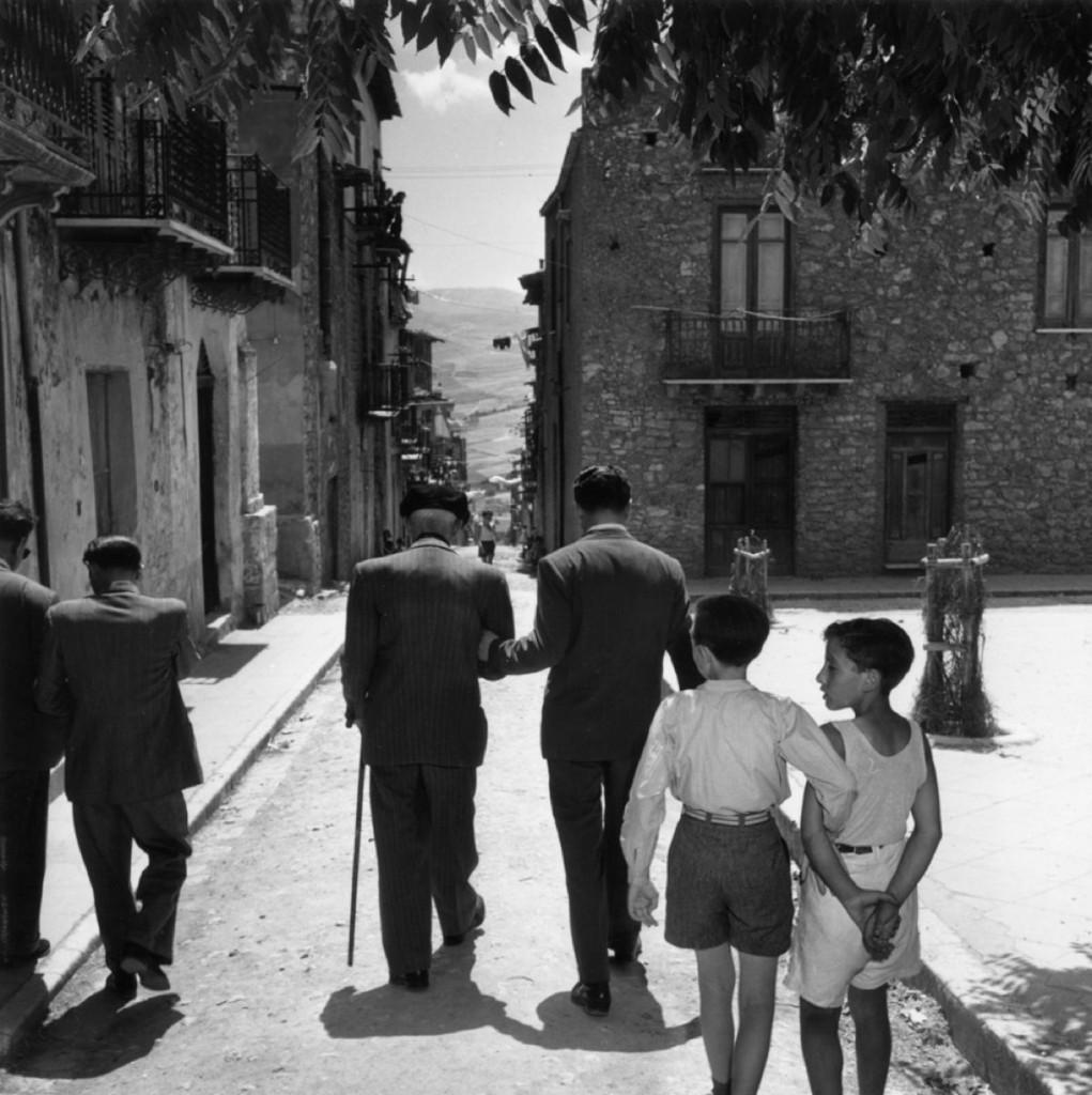 'Lucky For Some' 1949 

Slim Aarons Limited Edition Estate Print

1949: Sicilian-born gangster Charles ‘Lucky’ Luciano (1897 – 1962) walking down a street in his native Sicily, followed by local children mimicking his posture. 

Whilst in prison