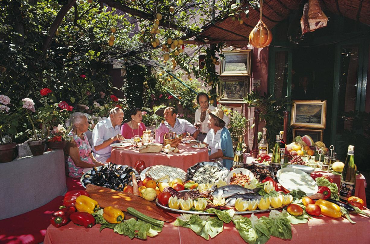 Lunch At La Pigna 
1980
by Slim Aarons

Slim Aarons Limited Estate Edition

US restaurateurs Gilda Cioffi, owner of Mama Gilda in Palm Beach, Guy Avventuiero and his wife, of Gino’s in New York, Gus and Geraldine Pucillo, of the Petite Marmite in