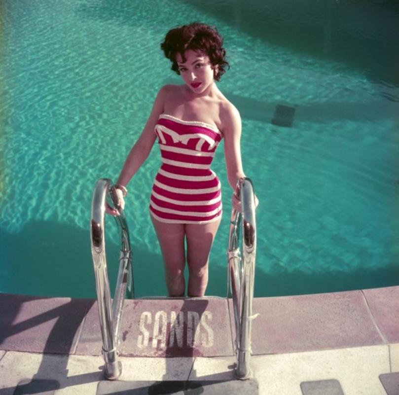 Mara Lane 
1954
by Slim Aarons

Slim Aarons Limited Estate Edition

Austrian actress Mara Lane posing by the pool at the Sands Hotel, Las Vegas, in a red and white striped bathing costume.

unframed
c type print
printed 2023
20 x 20"  - paper