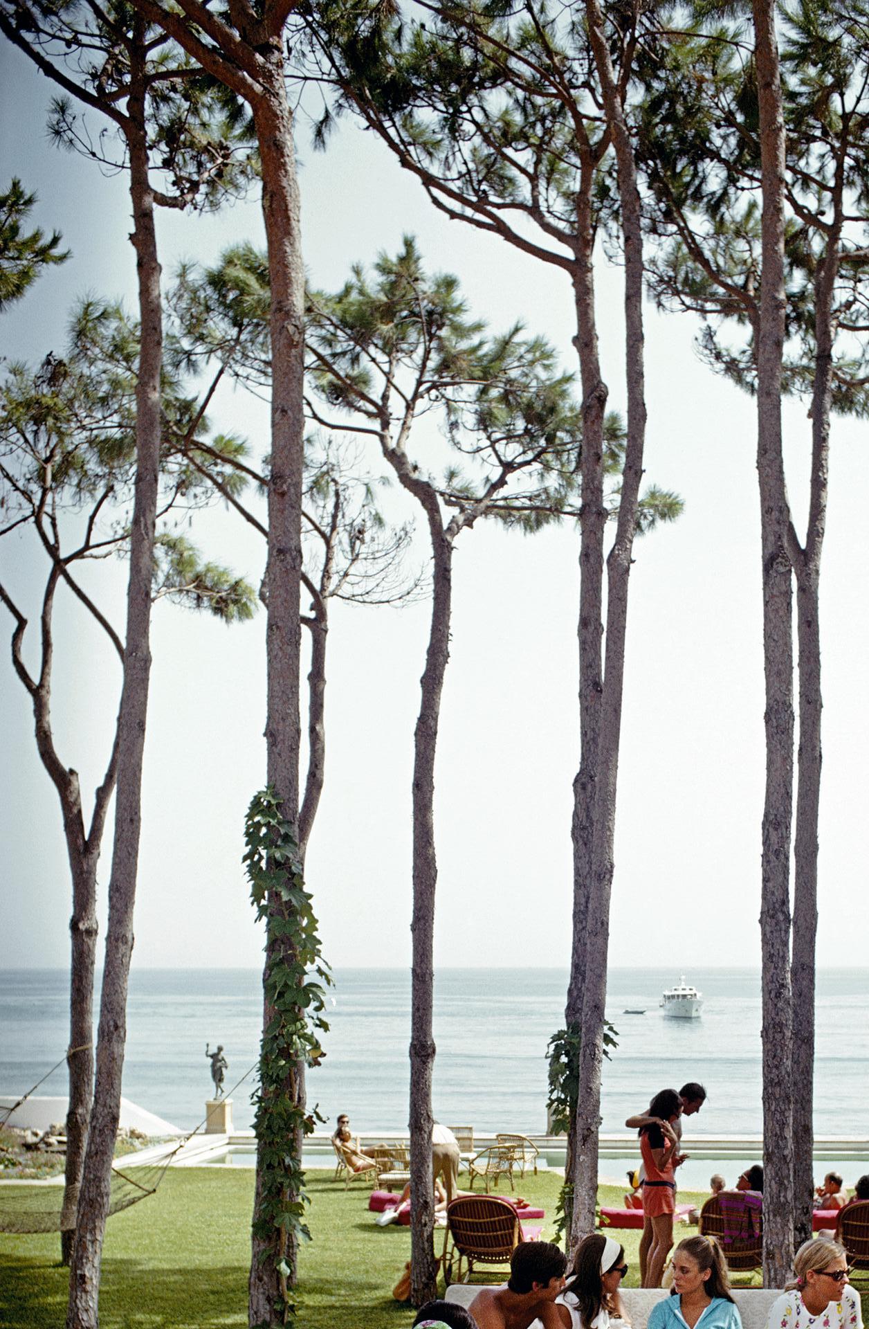 Dieses Porträtfoto des Society-Fotografen Slim Aarons aus den späten 1960er Jahren zeigt die Gäste einer Party im Haus von Sebastiano Bergese in Marbella, Spanien.

Dies ist eine nachlassgestempelte und handnummerierte Auflage von 150 Stück mit