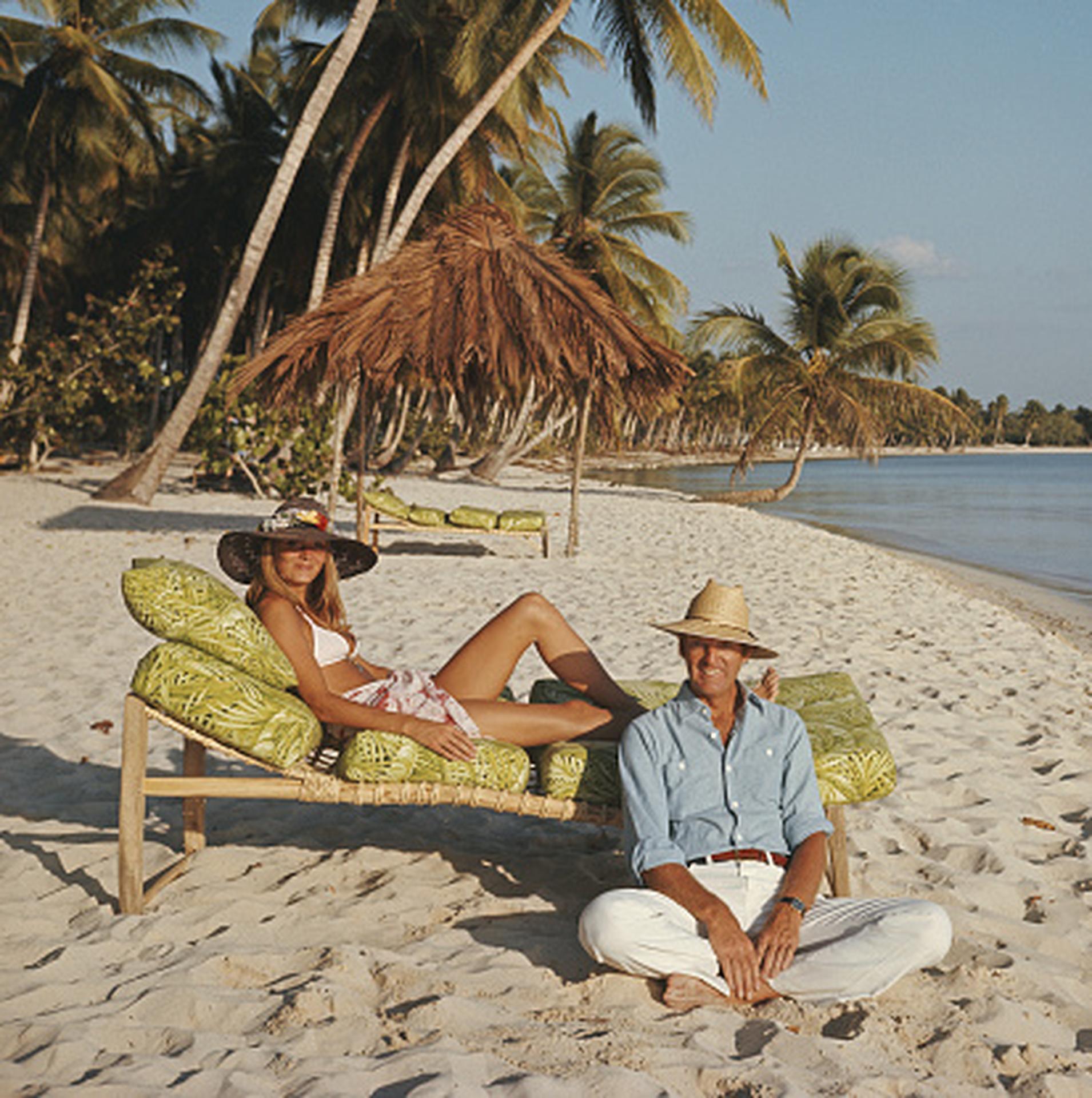 Minnie und Dru Montagu, Dominikanische Republik, Nachlassausgabe, Porträtfoto

Dieses Porträtfoto aus den 1970er Jahren, aufgenommen vom Society-Fotografen Slim Aarons, zeigt Minnie und Dru Montagu beim Entspannen am Strand von Casa de Campo,