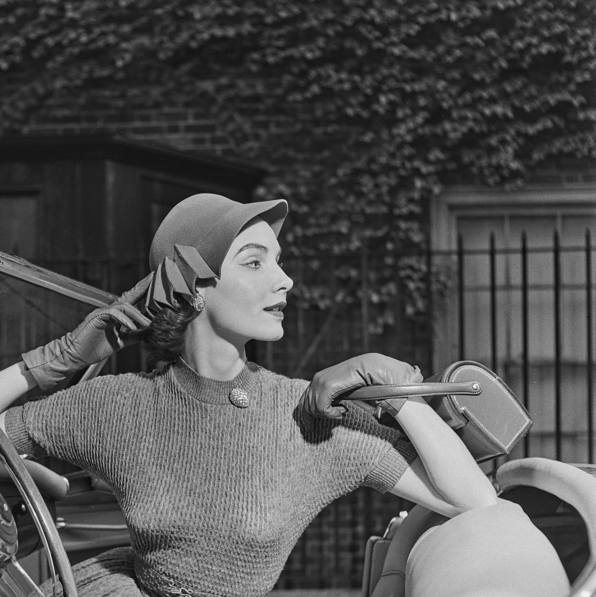Dieses Porträtfoto des Society-Fotografen Slim Aarons aus der Mitte der 1950er Jahre zeigt eine junge Frau, die für einen Saks Fifth Avenue-Katalog Modell steht.

Dies ist eine nachlassgestempelte und handnummerierte Auflage von 150 Stück mit