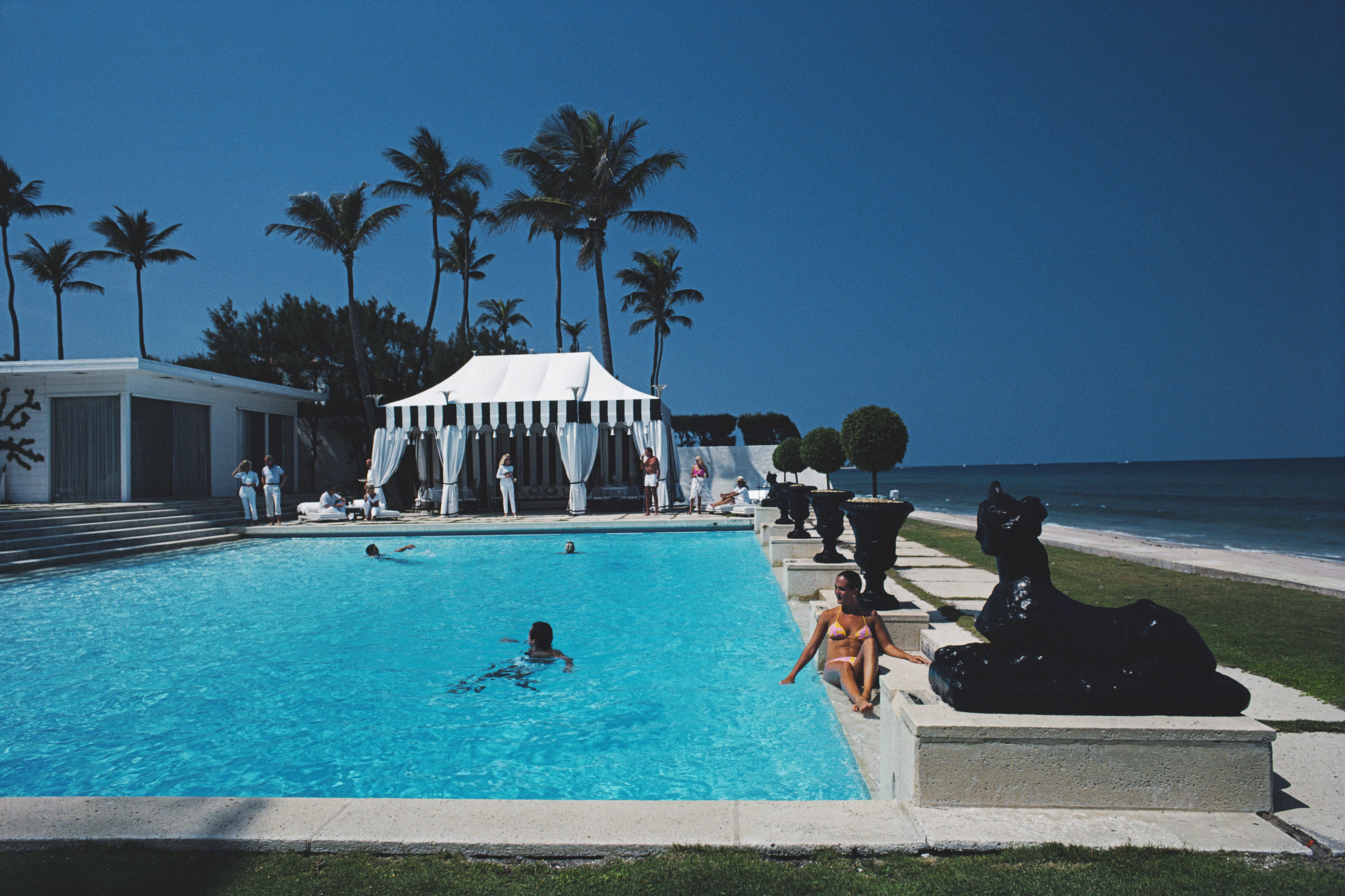 'Molly Wilmot's Pool' 1982 Slim Aarons Limited Estate Edition Print 

Guests relaxing around the pool at the home of Molly Wilmot, Palm Beach, Florida, April 1982. 
(Photo by Slim Aarons/Getty Images)

Produced from the original