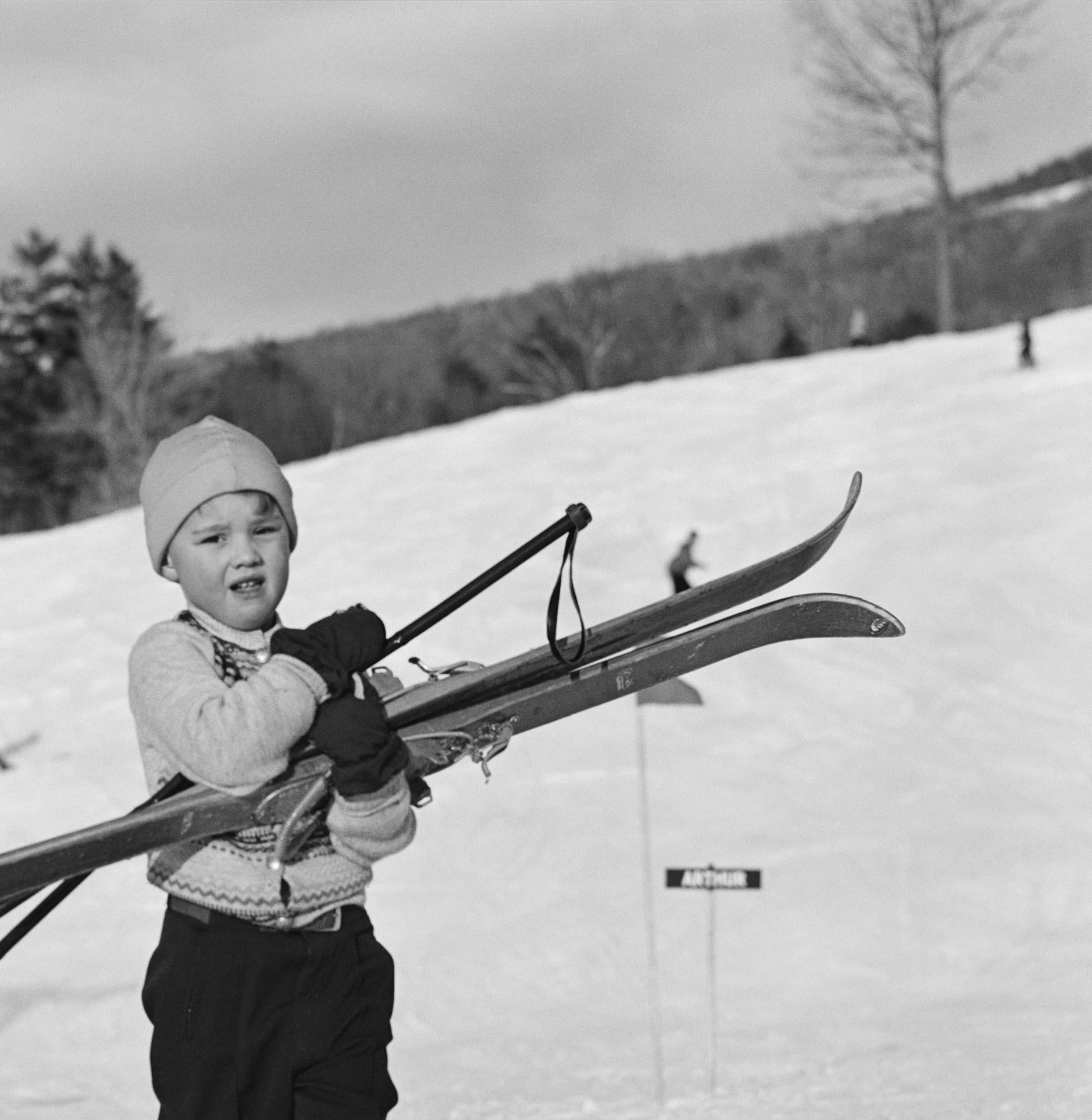 Dans ce paysage hivernal classique en noir et blanc du milieu du siècle, capturé par le photographe mondain Slim Aarons, un jeune skieur préfère porter ses propres skis pour dévaler la pente dans le New Hampshire, en 1955.

Il s'agit d'une édition