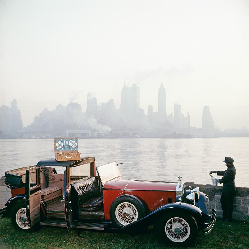 Picnic a New York 

Un autista disfa un cesto da picnic da una Rolls Royce, sullo sfondo dell'iconico skyline di New York, 1952.

Splendida stampa di dimensioni extra large 40 x 40" pollici / circa 101 x 101 cm.
 
Collection'S con francobollo di