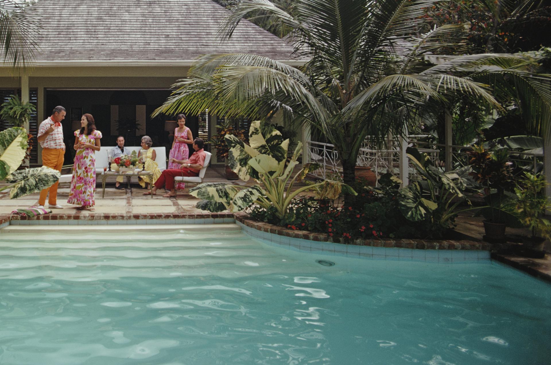 Diese Landschaftsaufnahme des Society-Fotografen Slim Aarons aus den frühen 1970er Jahren zeigt Gäste, die sich am Swimmingpool von John Youngs Villa 