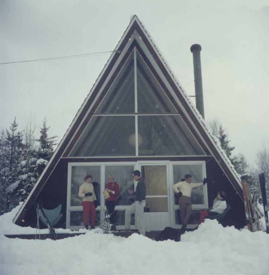 Sulle piste di Stowe 
1962
da Slim Aarons

Slim Aarons Edizione Limitata Estate

Cinque persone che si rilassano sulla terrazza della Skaal House, una casa triangolare con facciata in vetro, nella località sciistica di Stowe Mountain a Stowe,