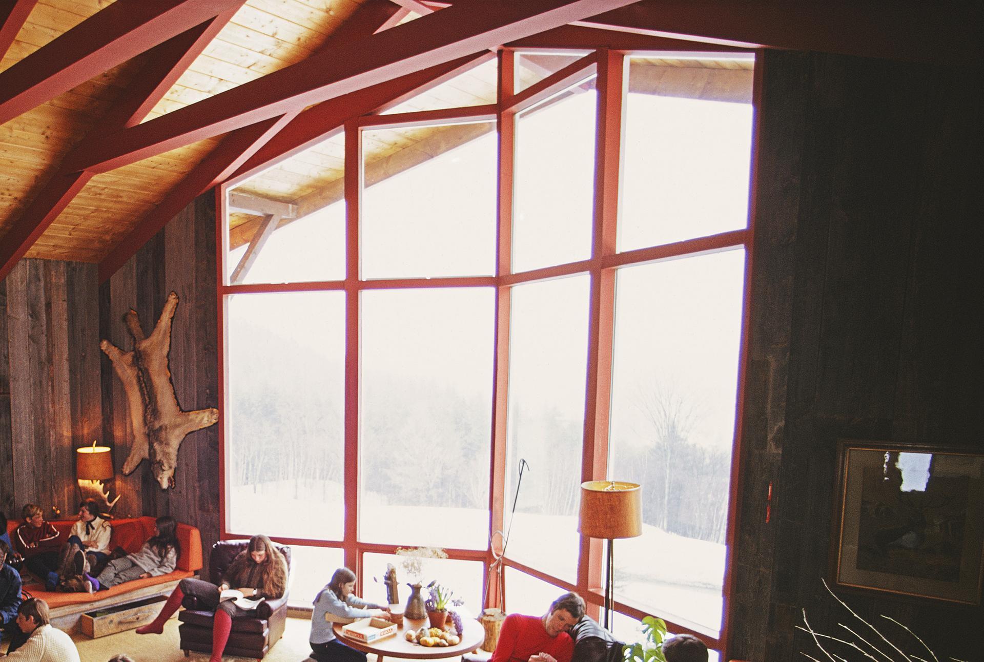 Diese Landschaftsfotografie aus der Mitte des Jahrhunderts, aufgenommen vom Society-Fotografen Slim Aarons, zeigt ein Chalet aus der Mitte des Jahrhunderts mit Blick auf das Sugarbush Mountain Ski Resort in Warren, Vermont, im Dezember 1960. Hier