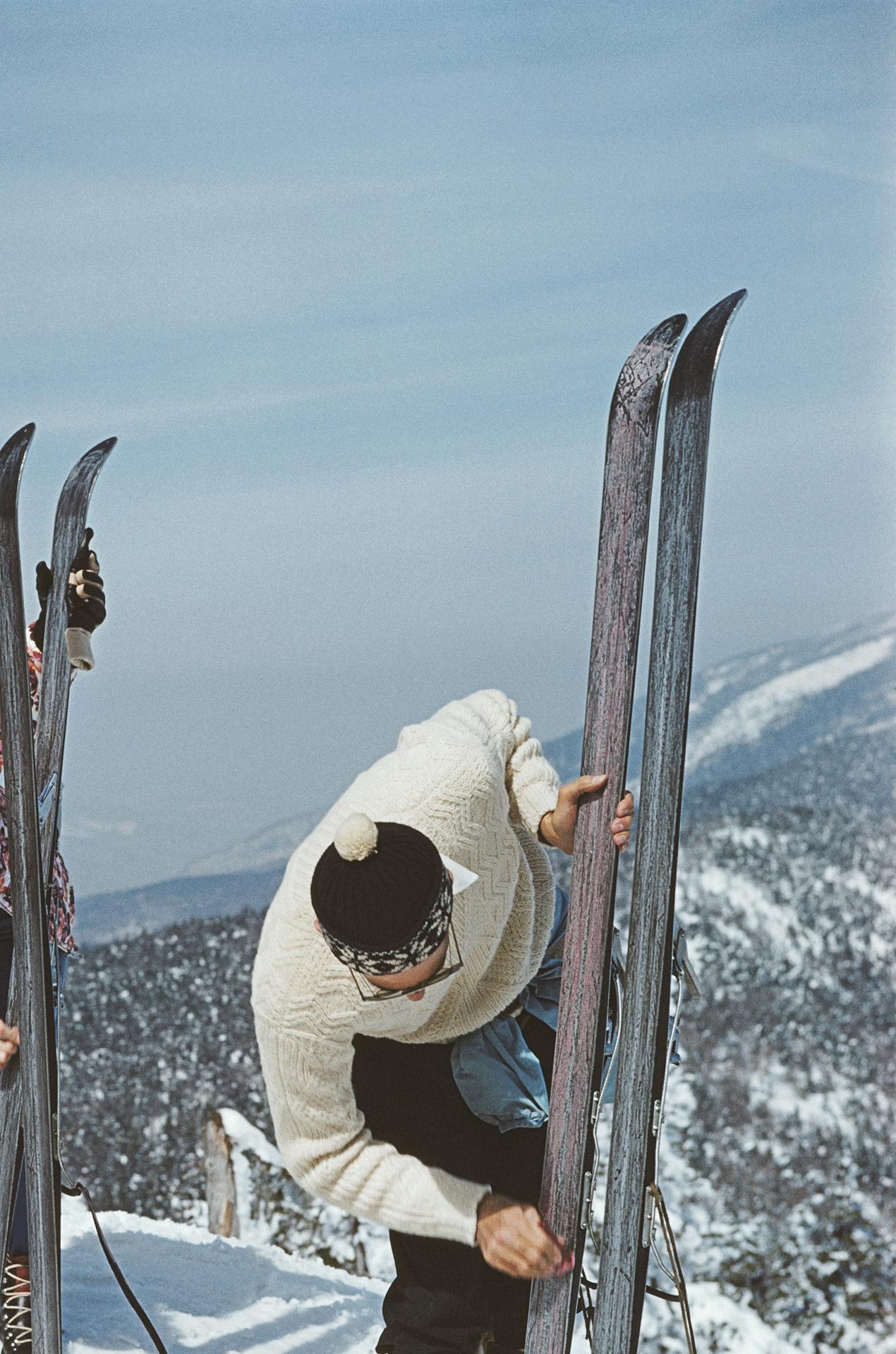 Cette photographie de portrait du début des années 1960, prise par le photographe mondain Slim Aarons, montre trois skieurs inspectant leurs skis sur les pentes de la station de ski de Sugarbush Mountain à Warren, dans le Vermont, aux États-Unis,