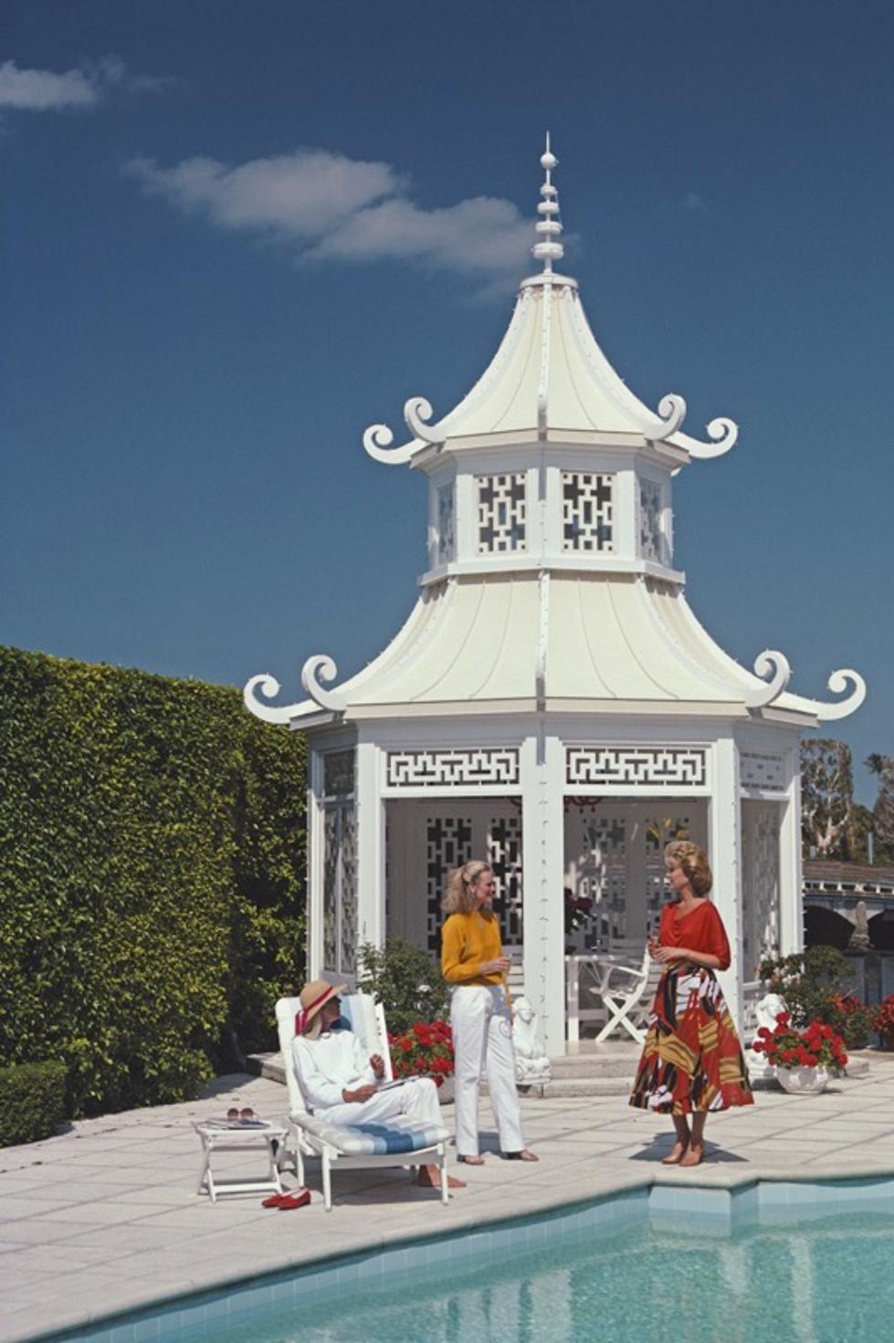 Palm Beach Pagoda 
1985
by Slim Aarons

Slim Aarons Limited Estate Edition

Cynthia Eichler (sitting) with Vicky Schaft Bruder (centre) and Cathy Tankoos (Mrs Joseph Tankoos) by the CHinese teahouse on Everglades Island in Palm Beach, Florida, April
