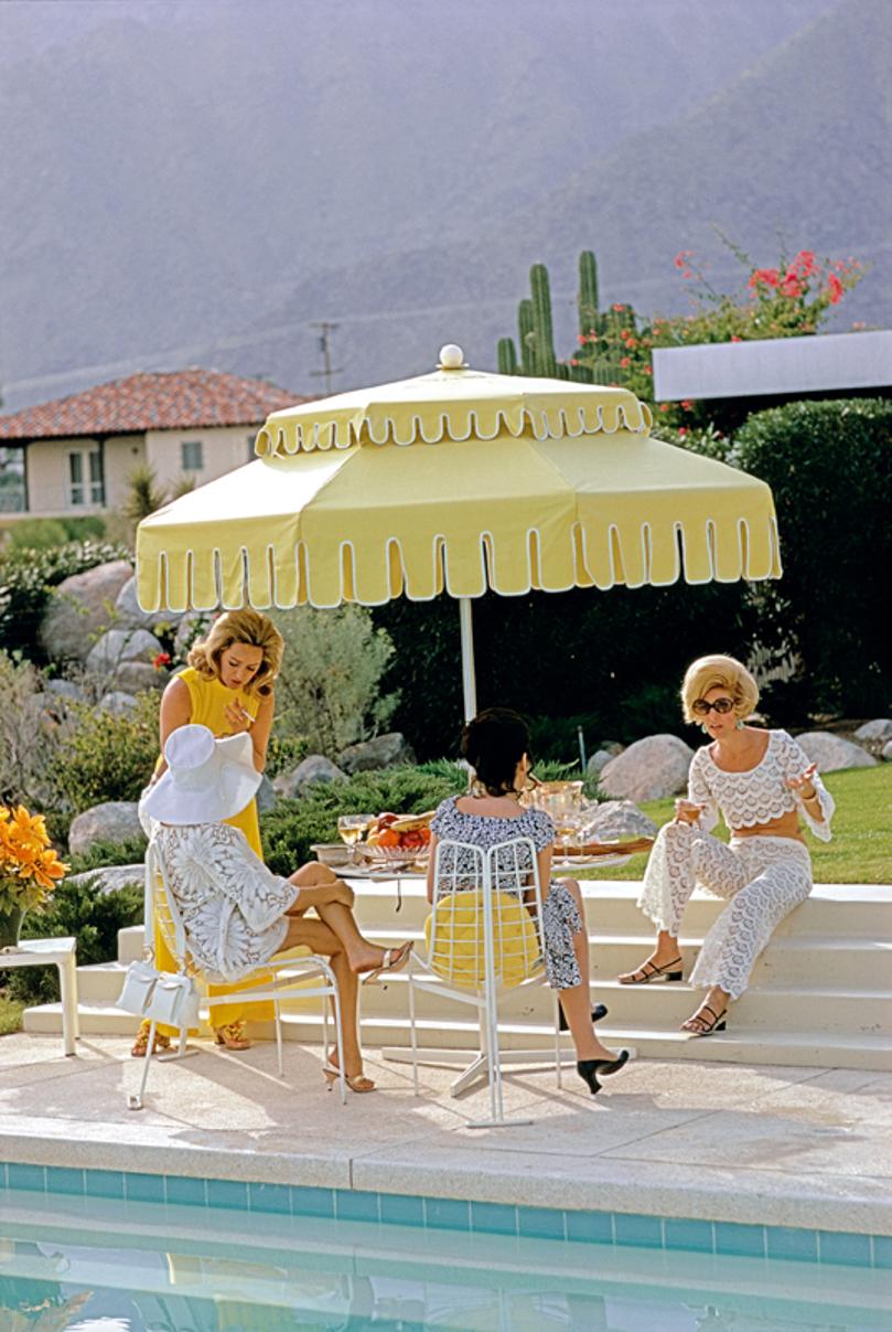 Palm Springs Life 
1970
by Slim Aarons

Slim Aarons Limited Estate Edition

Nelda Linsk (left, in yellow), wife of art dealer Joseph Linsk with guests by the pool at the Linsk’s desert house in Palm Springs, January 1970. At far left in white sunhat