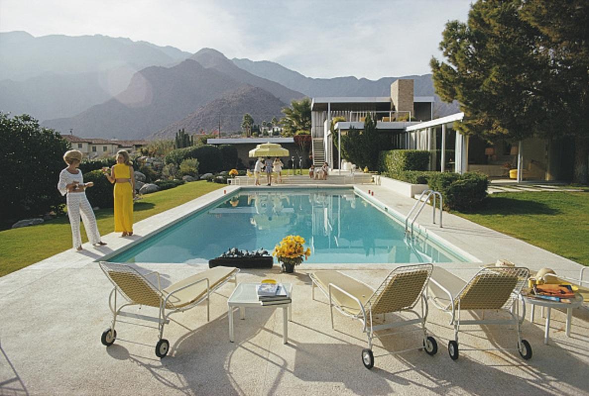'Palm Springs Pool' 1970 Slim Aarons Limited Estate Edition Print 

Former fashion model Helen Dzo Dzo Kaptur (in white lace) and Nelda Linsk (in yellow), wife of art dealer Joseph Linsk, at the Kaufmann Desert House in Palm Springs, California,