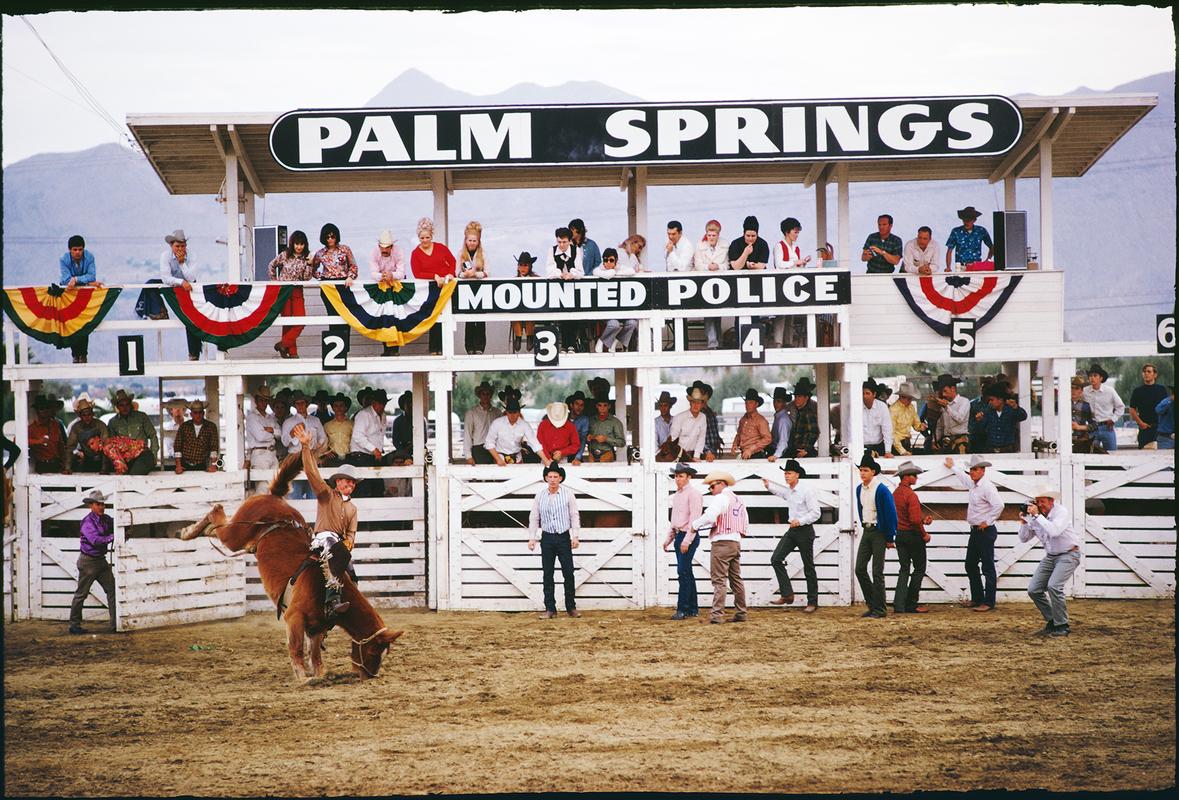 'Palm Springs Rodeo' 

Spectators watch from the stand as a contestant rides a bucking horse at the Palm Springs Mounted Police Rodeo, Palm Springs, California, January 1970. 

Paper Size  24x20 inches / 60 x 50 cm 
 
Estate Stamped Collection