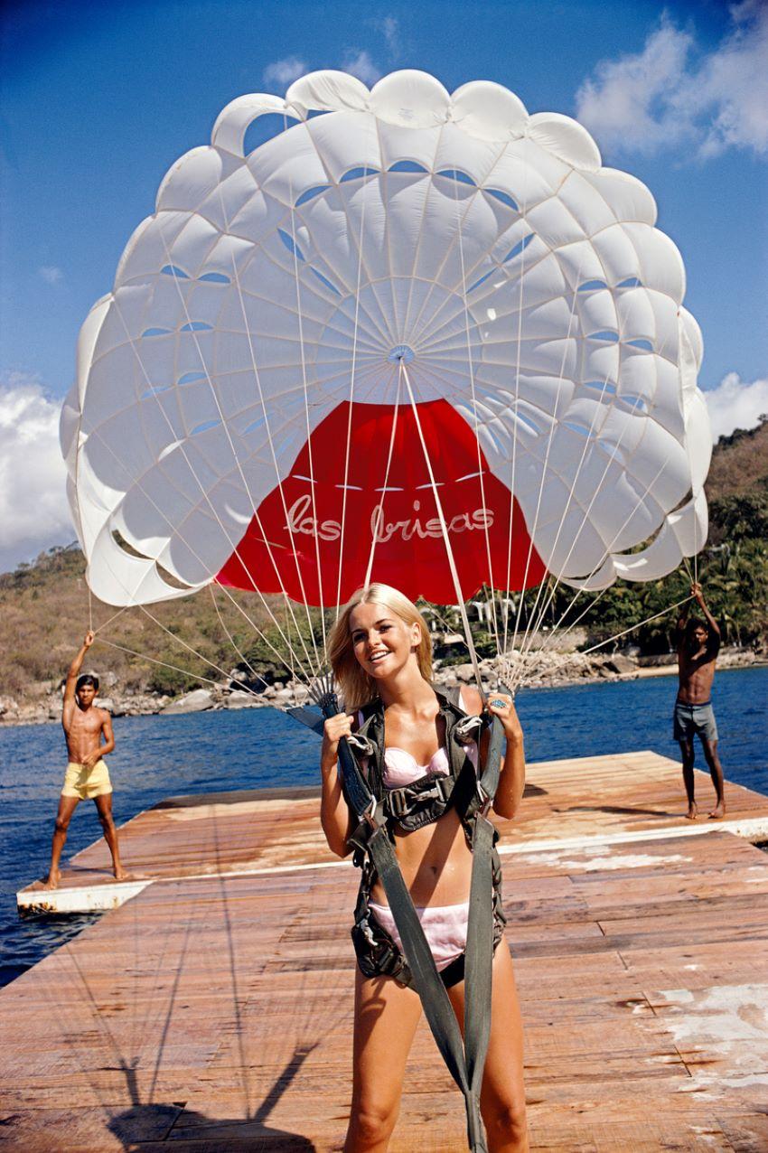 Paraglider 

1968

 Preparing to go paragliding in Acapulco a young blonde woman holds on firmly to her parachute harness. 1968

By Slim Aarons

12x16” / 30 x 41 cm - paper size 
Archival pigment print
unframed 
(framing available see examples -