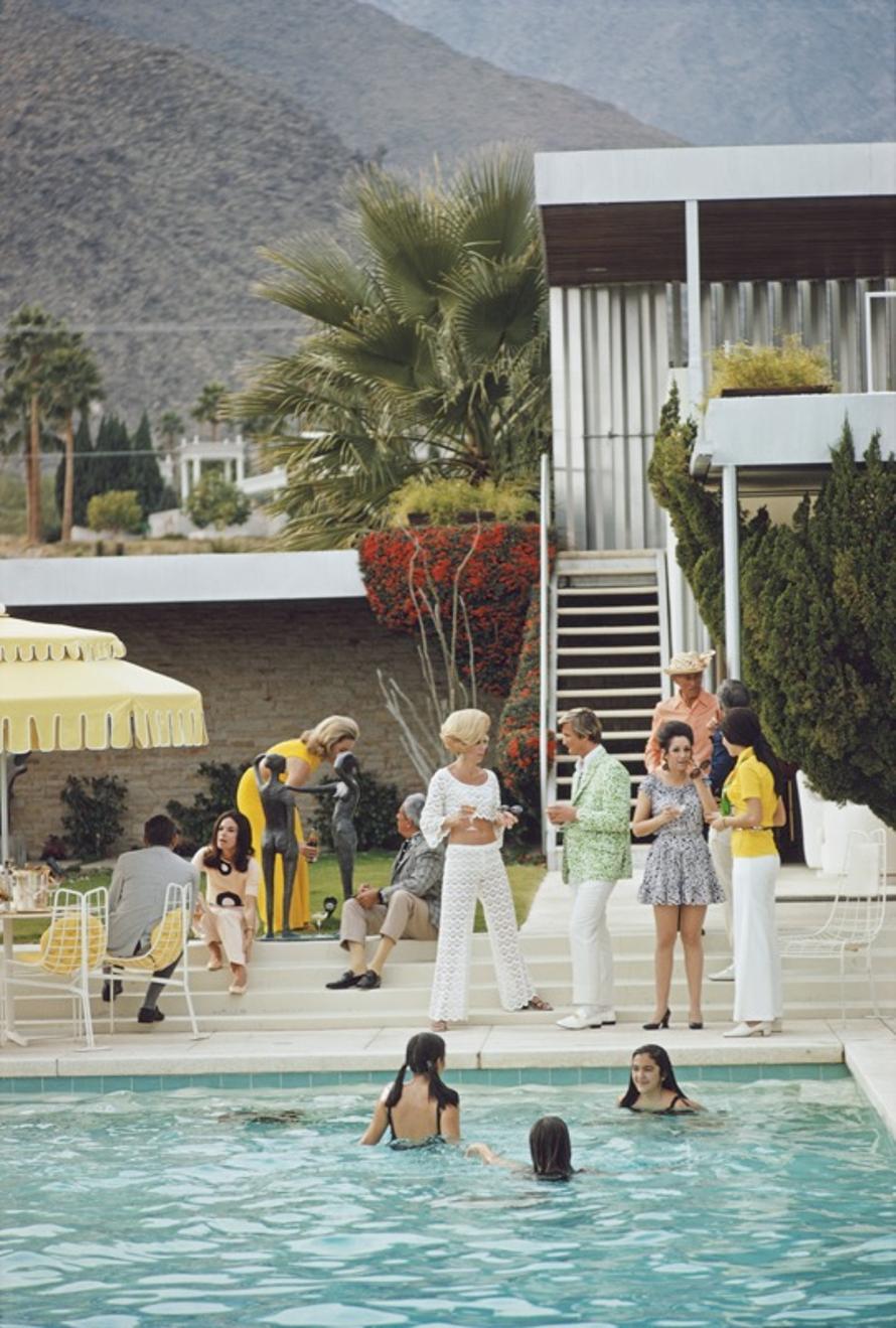 Festa sui gradini 
1970
da Slim Aarons

Slim Aarons Edizione Limitata Estate

Ospiti in piscina nella casa nel deserto di Nelda Linsk a Palm Springs, California, gennaio 1970. La casa fu progettata da Richard Neutra per Edgar J. Kaufmann. Al centro