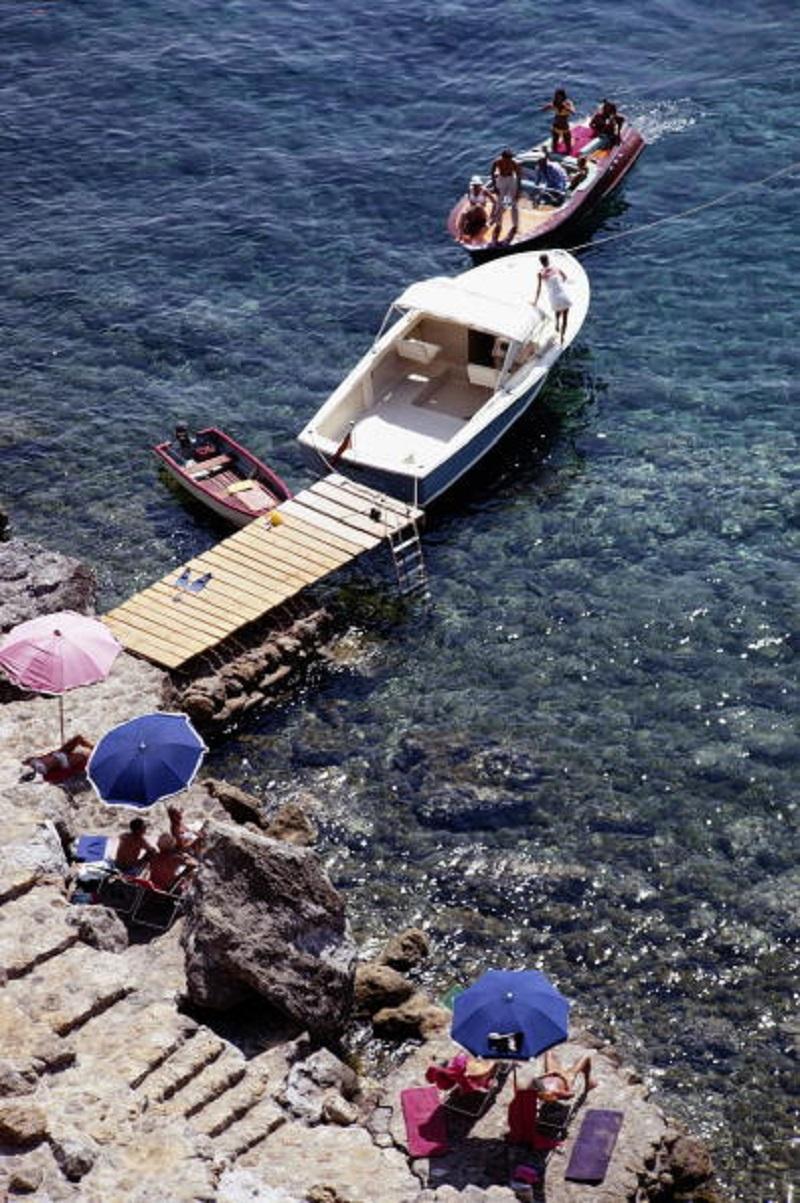 'Pellicano Beach' 1969 Slim Aarons Limited Estate Edition Print 

Boats at a jetty by the beach at the Hotel Il Pellicano in Porto Ercole, Tuscany, August 1969. 
(Photo by Slim Aarons/Hulton Archive/Getty Images)

Produced from the original