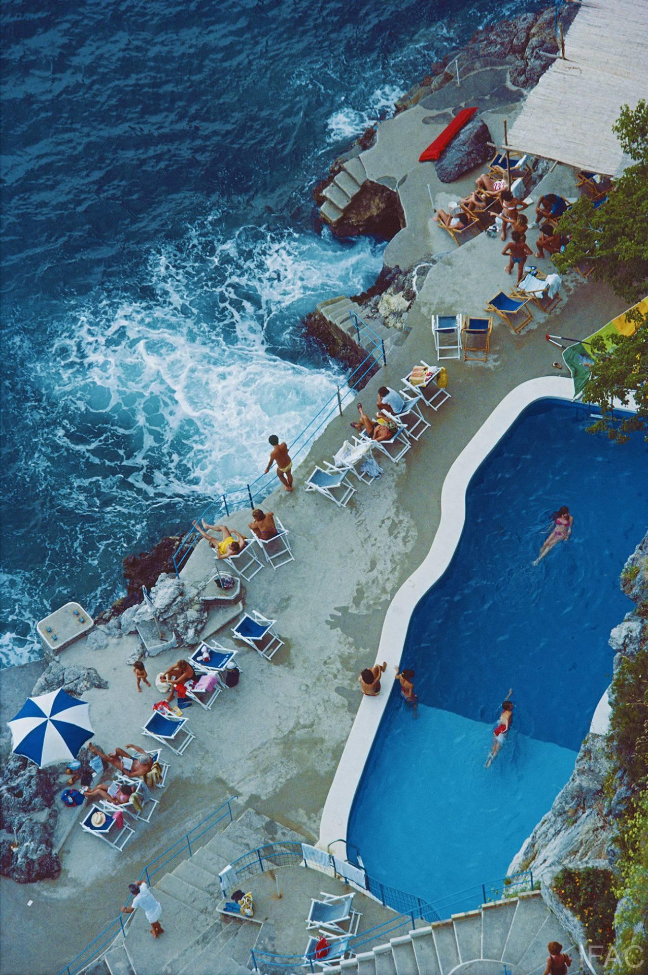 Schlanke Aarons
Pool an der Amalfiküste (Slim Aarons Estate Edition), 1984
Chromogener Lambda-Druck
Nachlassgestempelte und nummerierte Auflage von 150 Stück
60 x 40 Zoll

Blick auf den Pool am Meer im Hotel St. Caterina, Amalfi, Italien, September