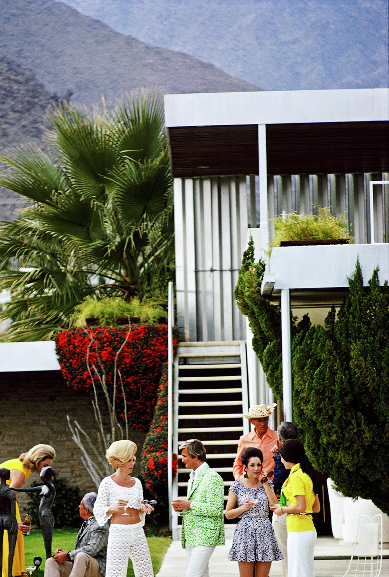 This early 1970s lifestyle photograph, captured by society photographer Slim Aarons, features guests by the pool at Nelda Linsk's desert house in Palm Springs, California, January 1970. The house was designed by Richard Neutra for Edgar J. Kaufmann.