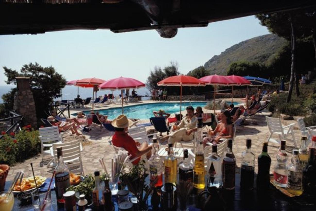 Poolside Bar 
1980
by Slim Aarons

Slim Aarons Limited Estate Edition

Guests seen from a poolside bar at the Hotel Il Pellicano in Porto Ercole, Italy, August 1980

unframed
c type print
printed 2023
20 x 24"  - paper size

Limited to 150 prints